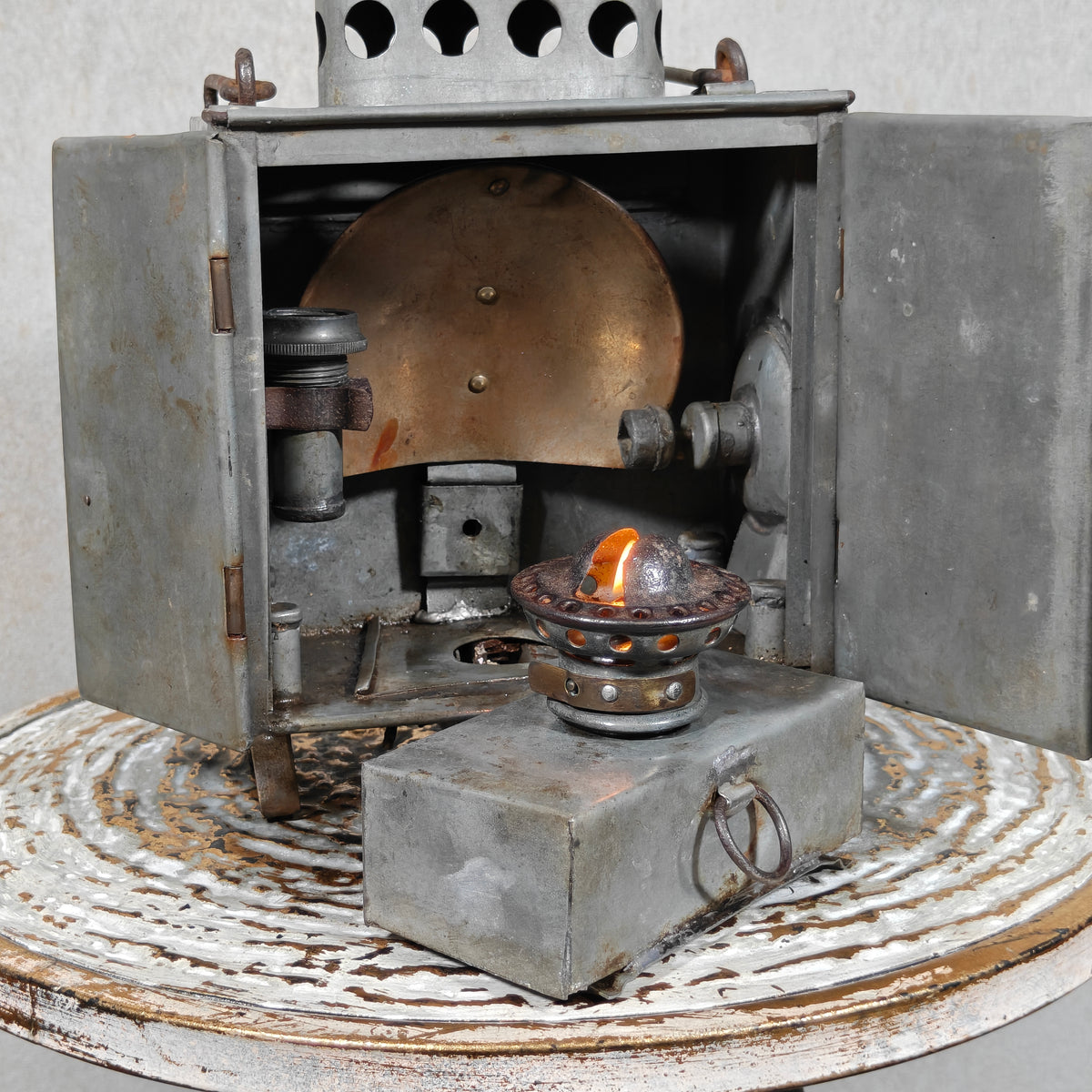 Very Rare Oil and Candle Trench Lamp – “Weltlaterne” by J. Schwarz & Co., Berlin, showing lit oil lamp inside open metal case