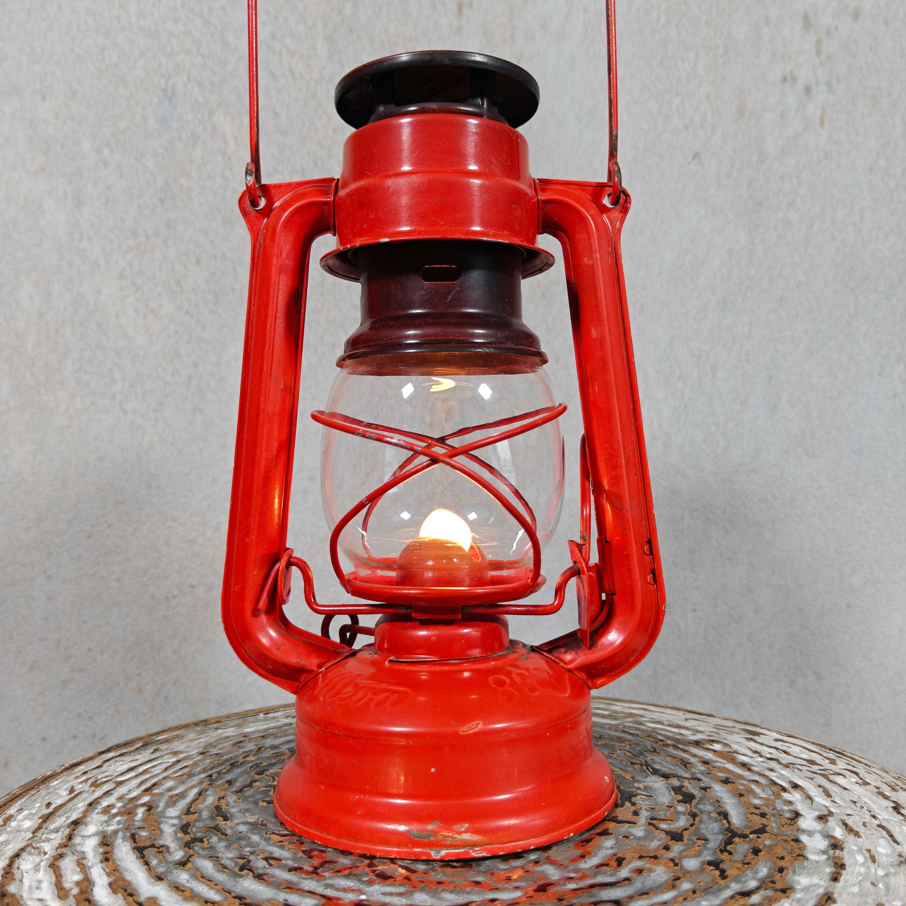 Beautiful and Functional Czech Storm Lantern – Meva 863 (1980) red oil lamp with glass chimney lit on metal surface