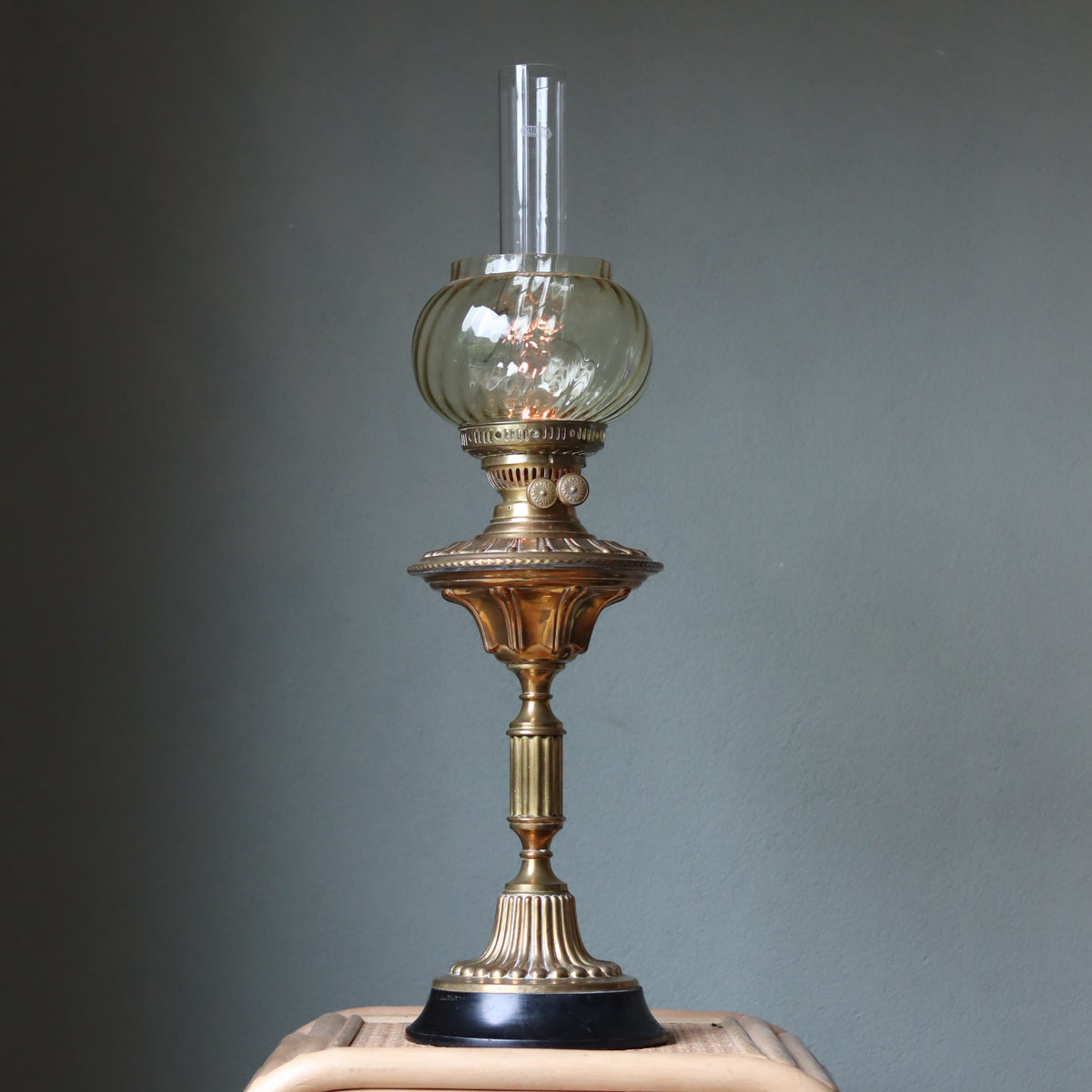 Vintage Brass Oil Lamp – Duplex Double Wick Burner – Yellow Glass Shade – 1950s–1970s standing on wooden surface against gray wall