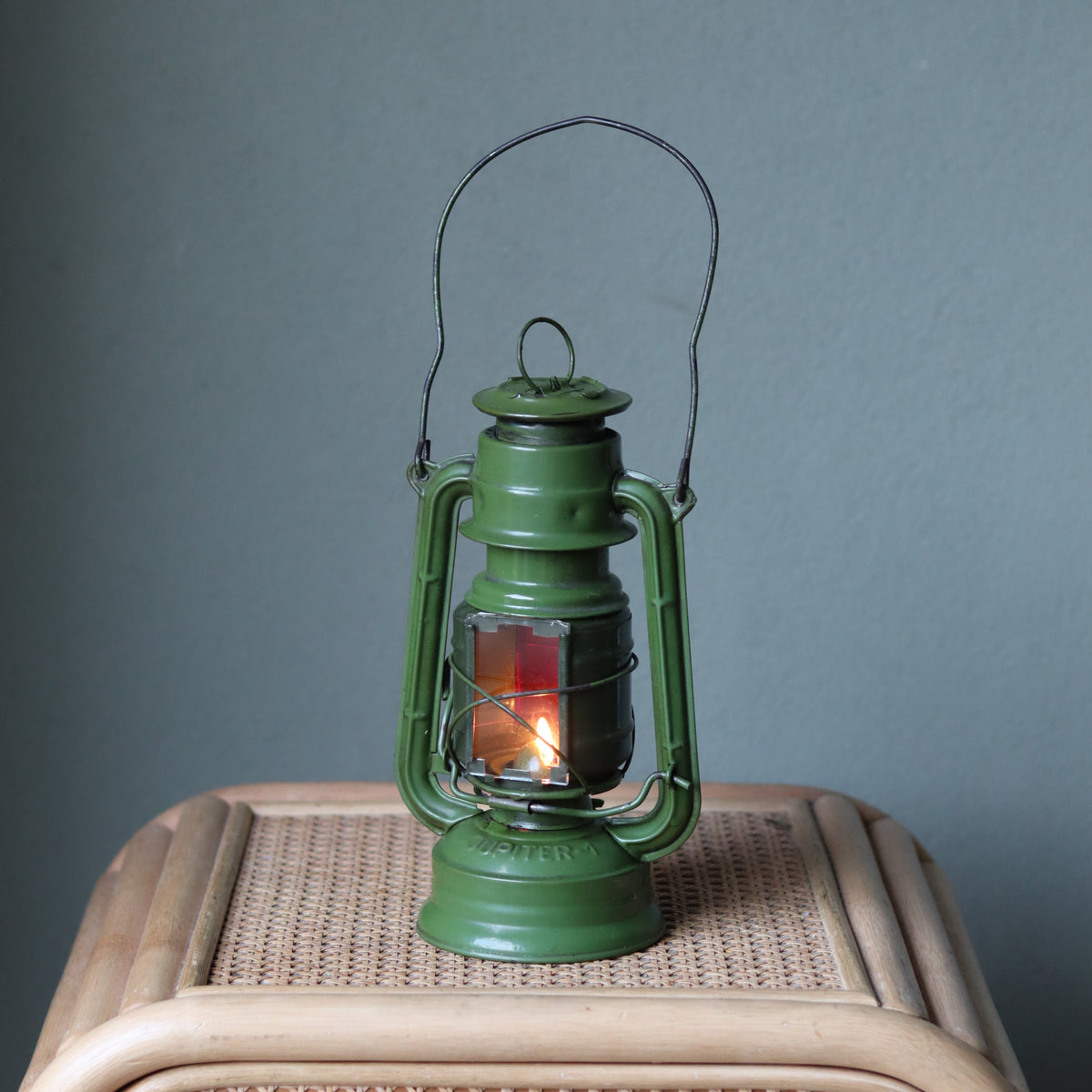 Rare Vintage Jupiter-1 Green Hurricane Lantern – Unique Flat Glass Holder with Red & Clear Panels glowing on wicker surface