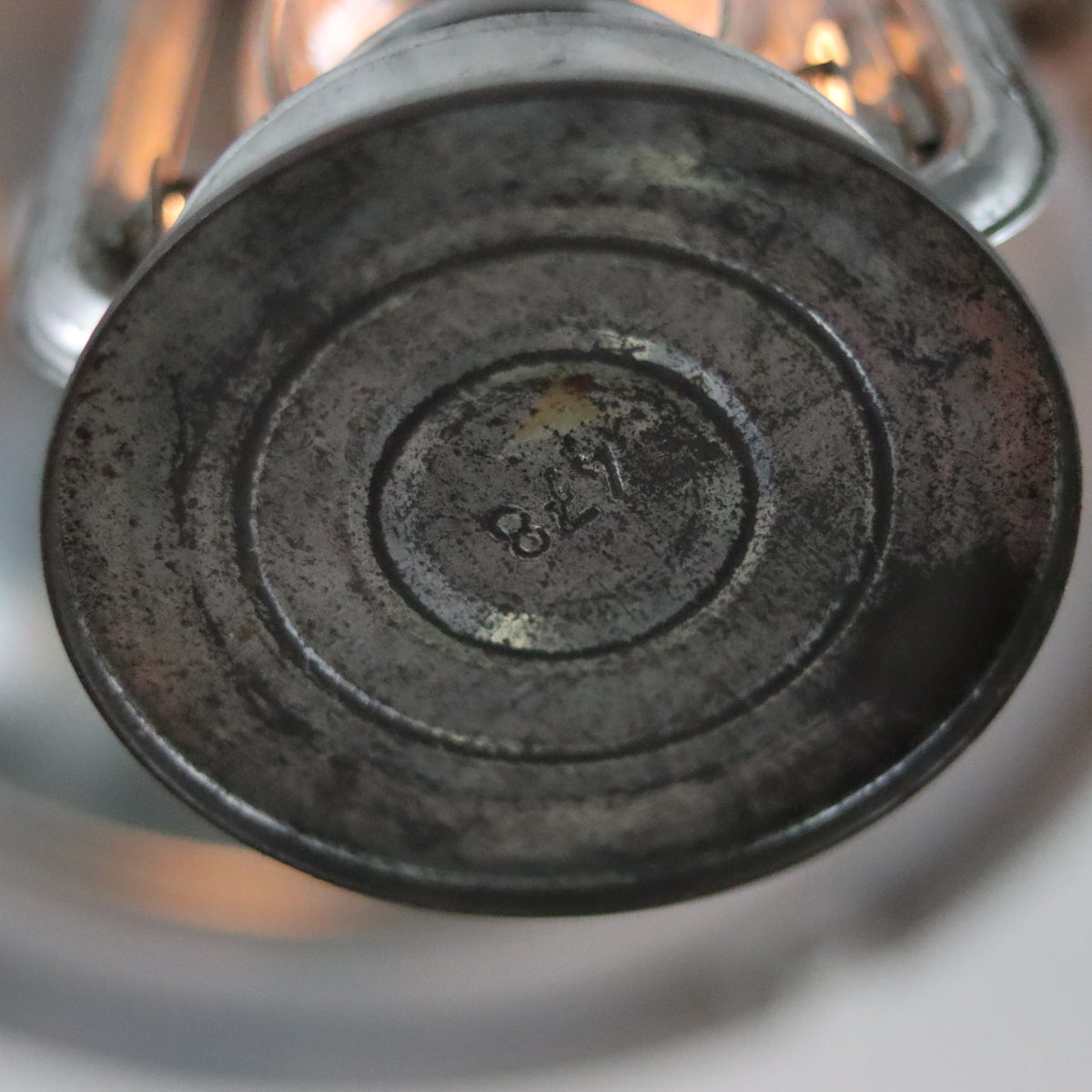 Close-up of the base showing wear on the Vintage Mewa Hurricane Lantern – Model 864 (1978) oil lamp metal surface