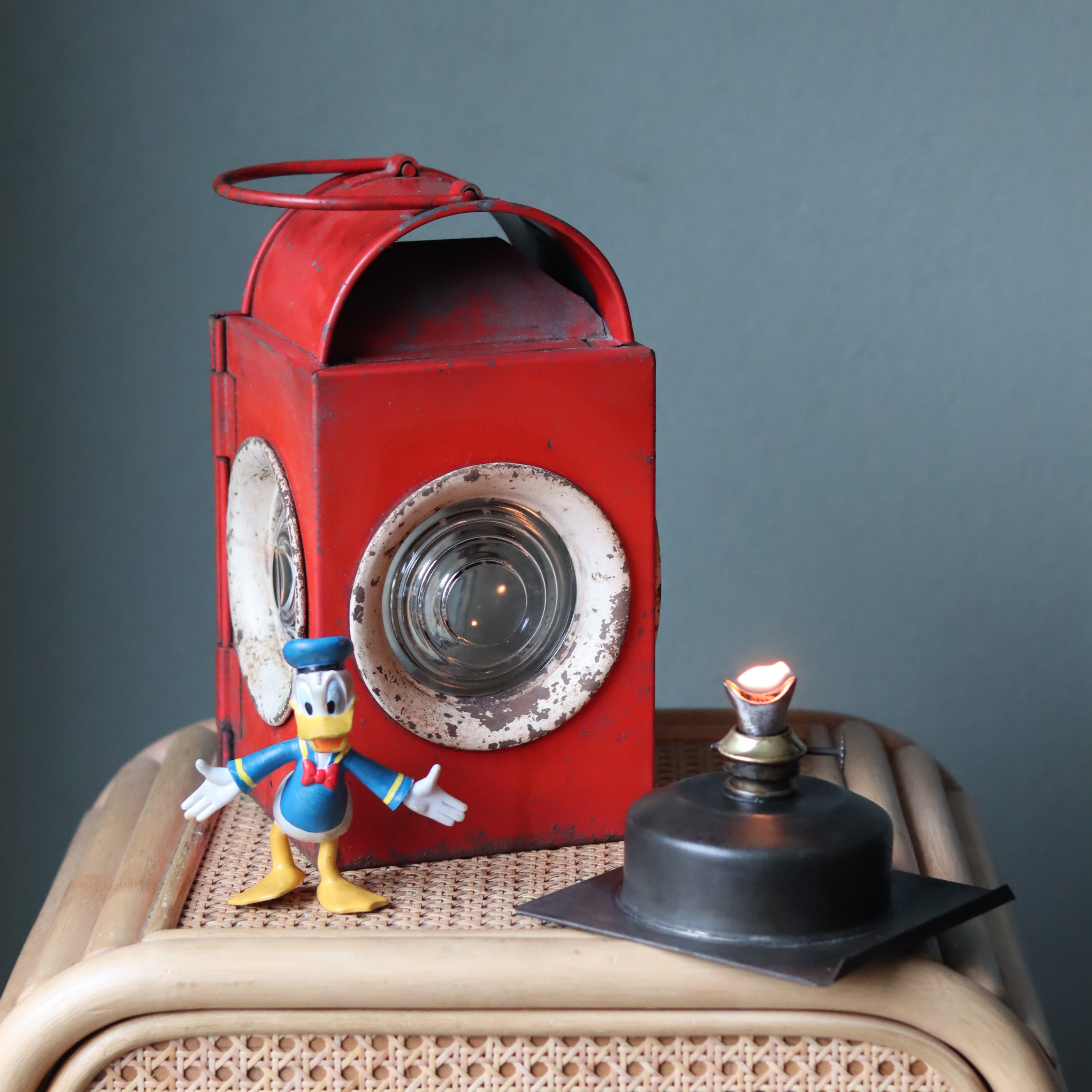 Vintage Roadwork Oil Lamp – A. Sartorius Wuppertal with Fishtail Burner (1960s) displayed with lit burner and red metal housing.