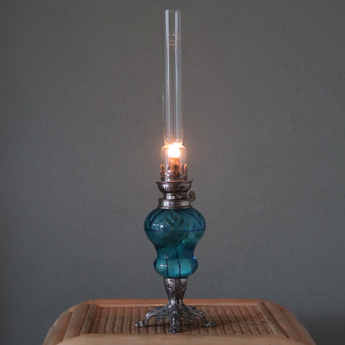 Rare Vintage French Oil Lamp – SI Paris Burner – Chrome Base & Blue Glass Reservoir – 1930s lit and standing on wooden surface