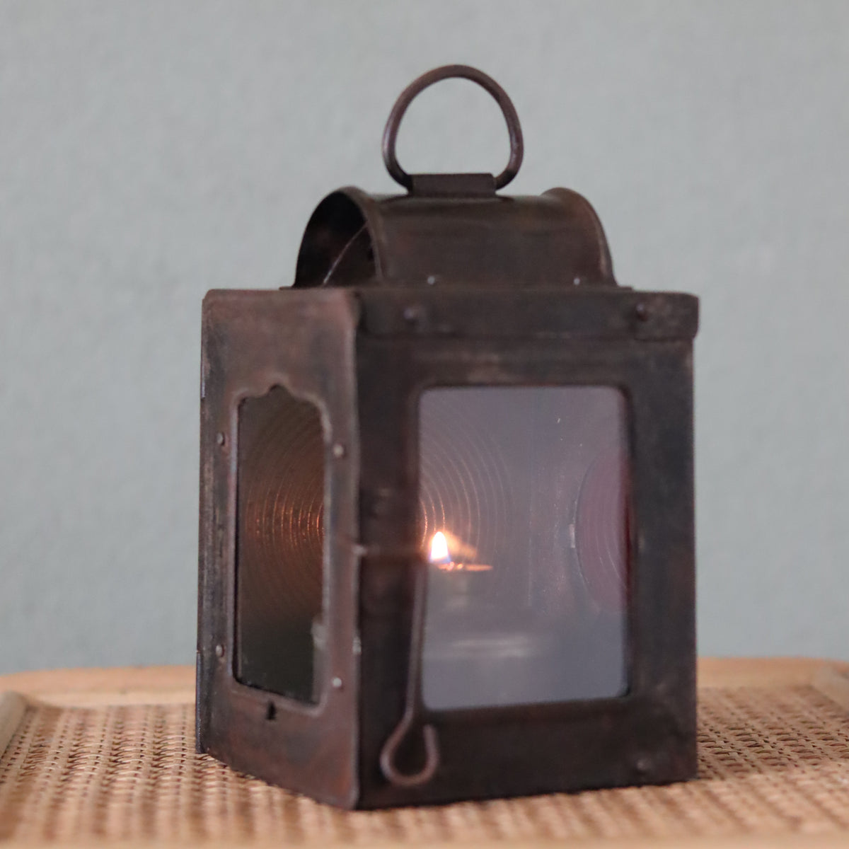 Rare Vintage Lantern – 1930s Automotive or Carriage Lamp showing a lit oil lamp inside a rustic metal frame
