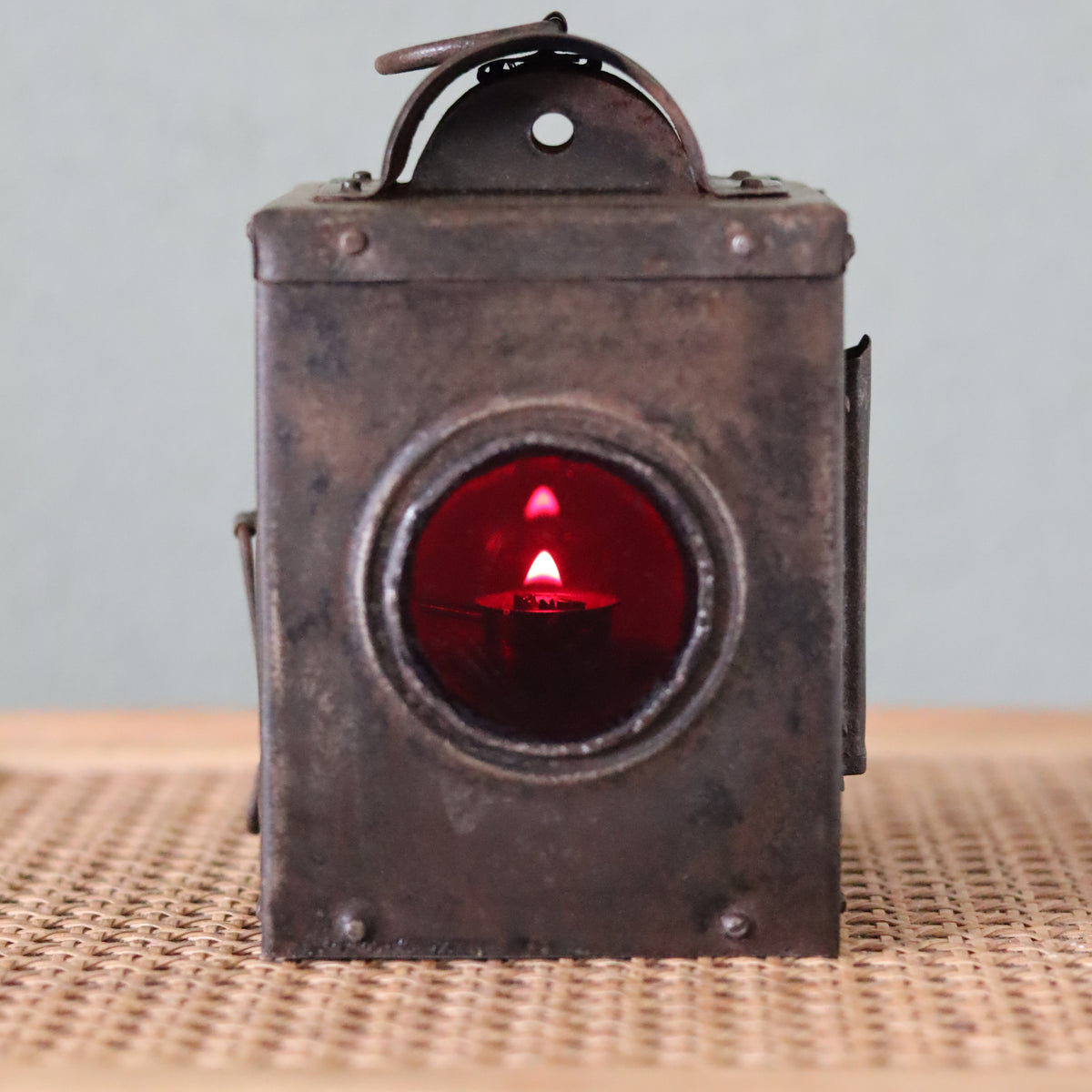 Rare Vintage Lantern – 1930s Automotive or Carriage Lamp showing an oil lamp lit with a red lens in antique metal housing