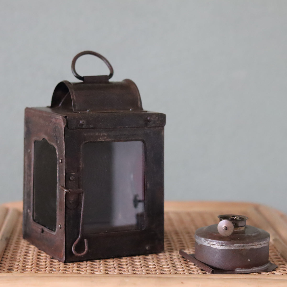 Rare Vintage Lantern – 1930s Automotive or Carriage Lamp oil lamp with metal frame and removable fuel container displayed on wicker surface