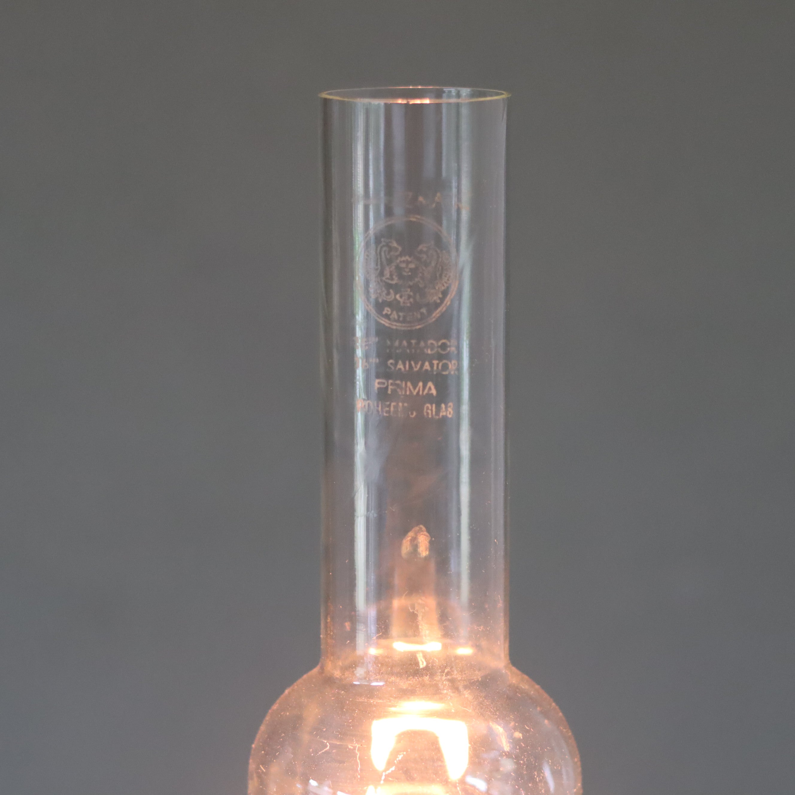 Rare Vintage Ceramic Oil Lamp – Tower Design with Wild & Wessel Burner (1930s) showing lit glass chimney and ceramic base