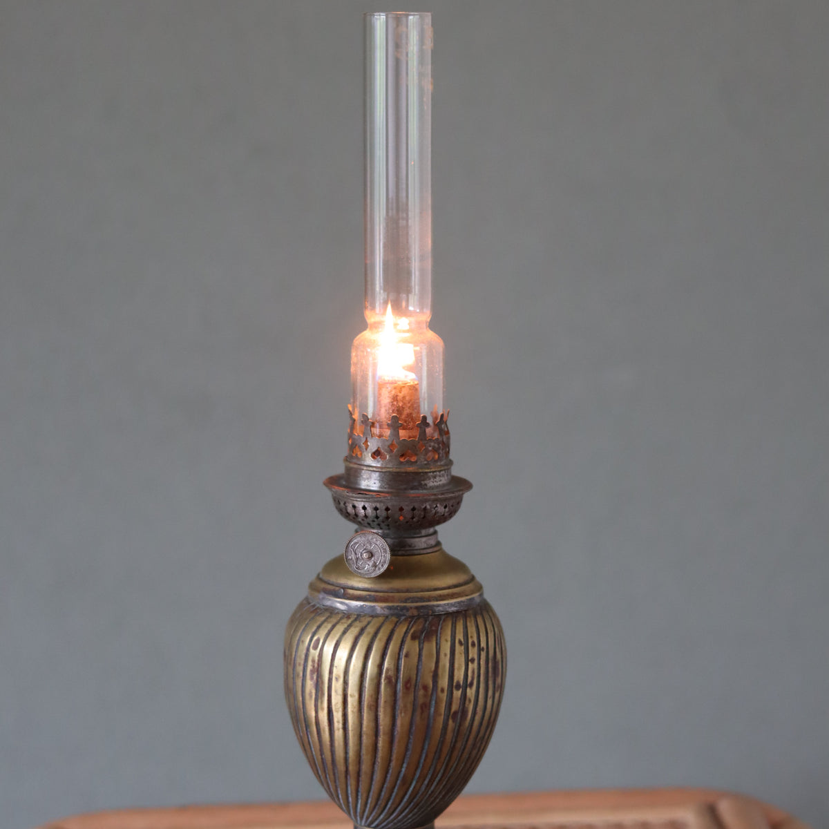 Vintage Oil Lamp with Wild & Wessel Burner – 1930s featuring a lit glass chimney and ornate brass base design