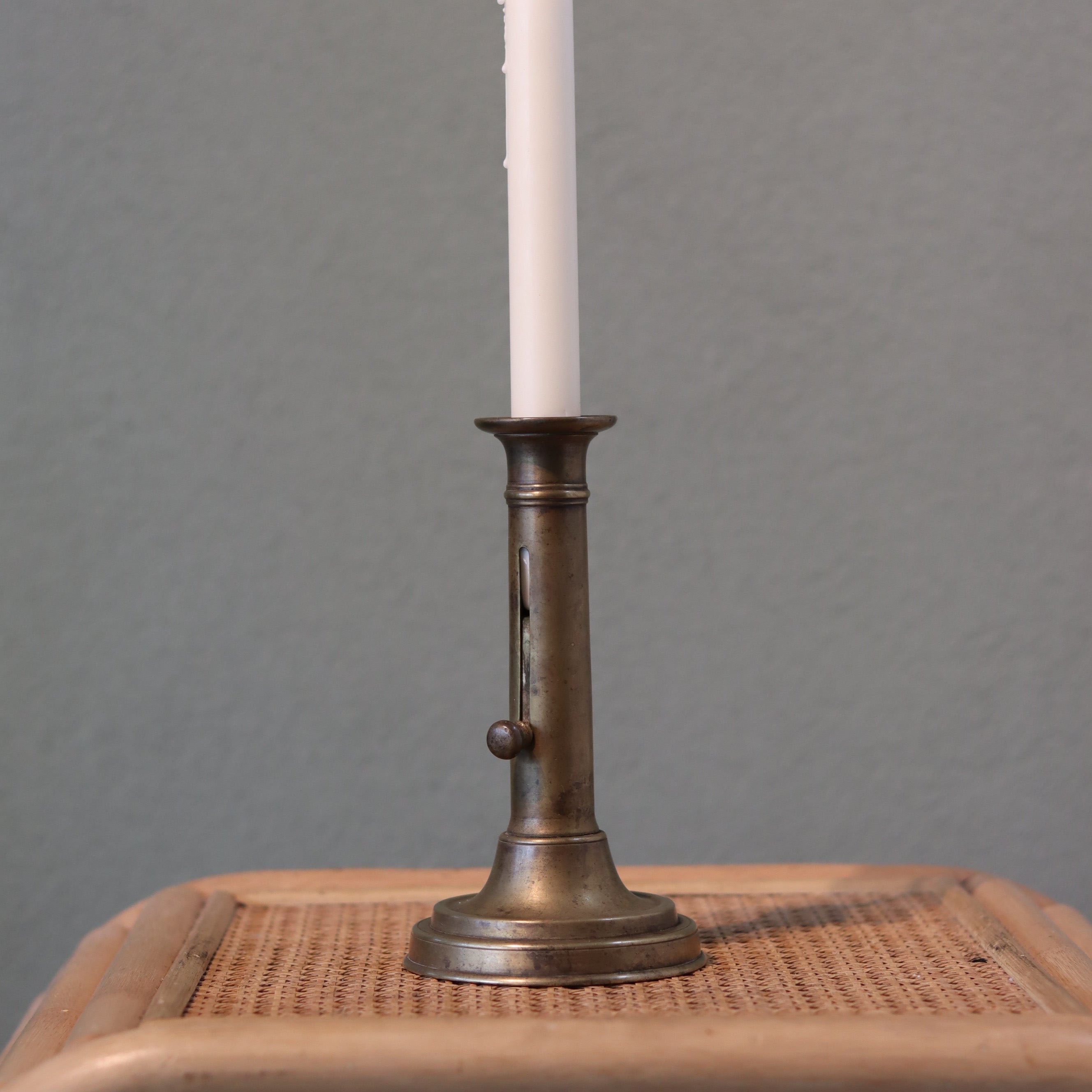 Vintage Bronze Candlestick with Adjustable Slide – Includes Candle – 1930s–1950s oil lamp style on wooden surface