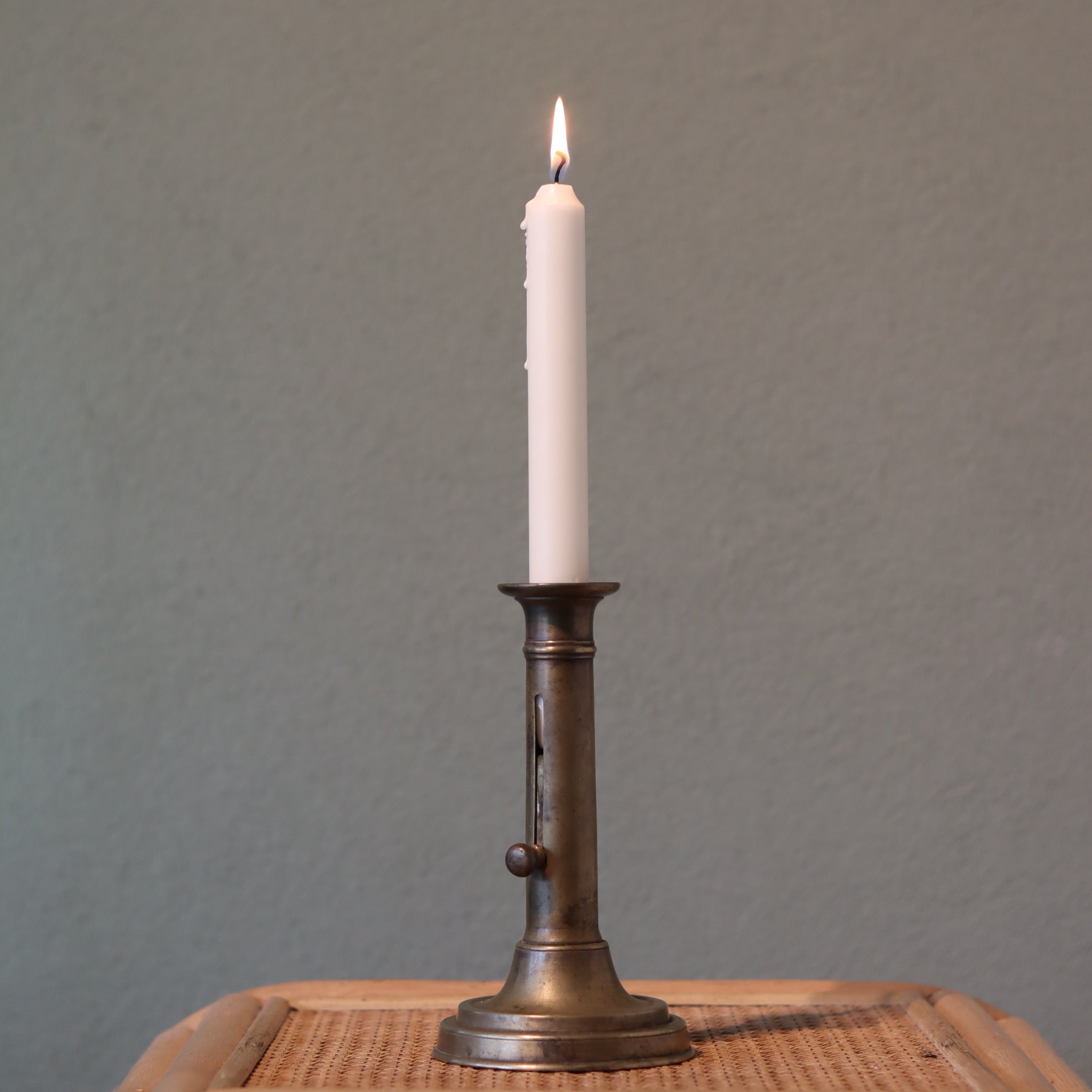 Vintage Bronze Candlestick with Adjustable Slide – Includes Candle – 1930s–1950s showing lit candle in bronze oil lamp design