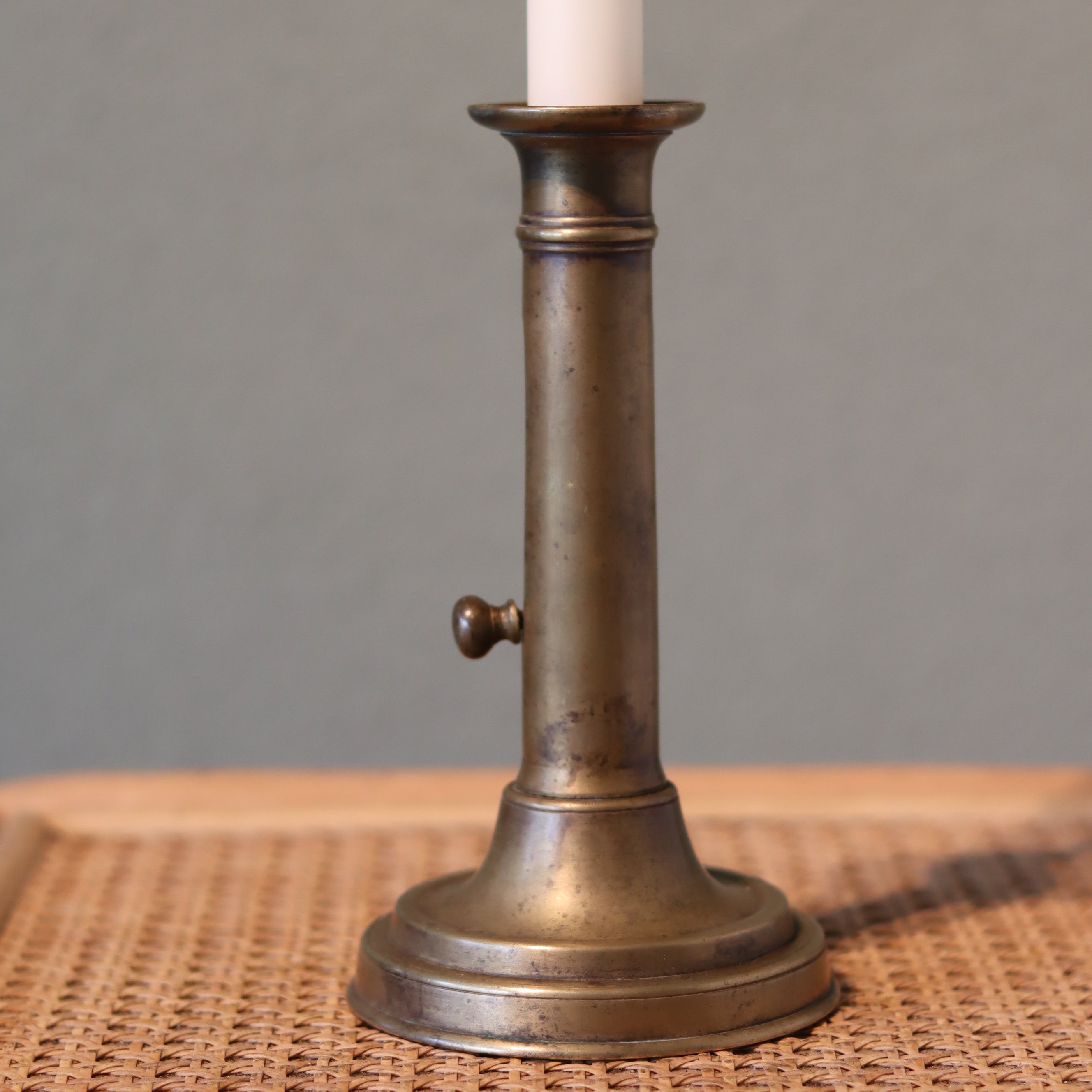 Vintage Bronze Candlestick with Adjustable Slide – Includes Candle – 1930s–1950s shown on woven surface with bronze finish