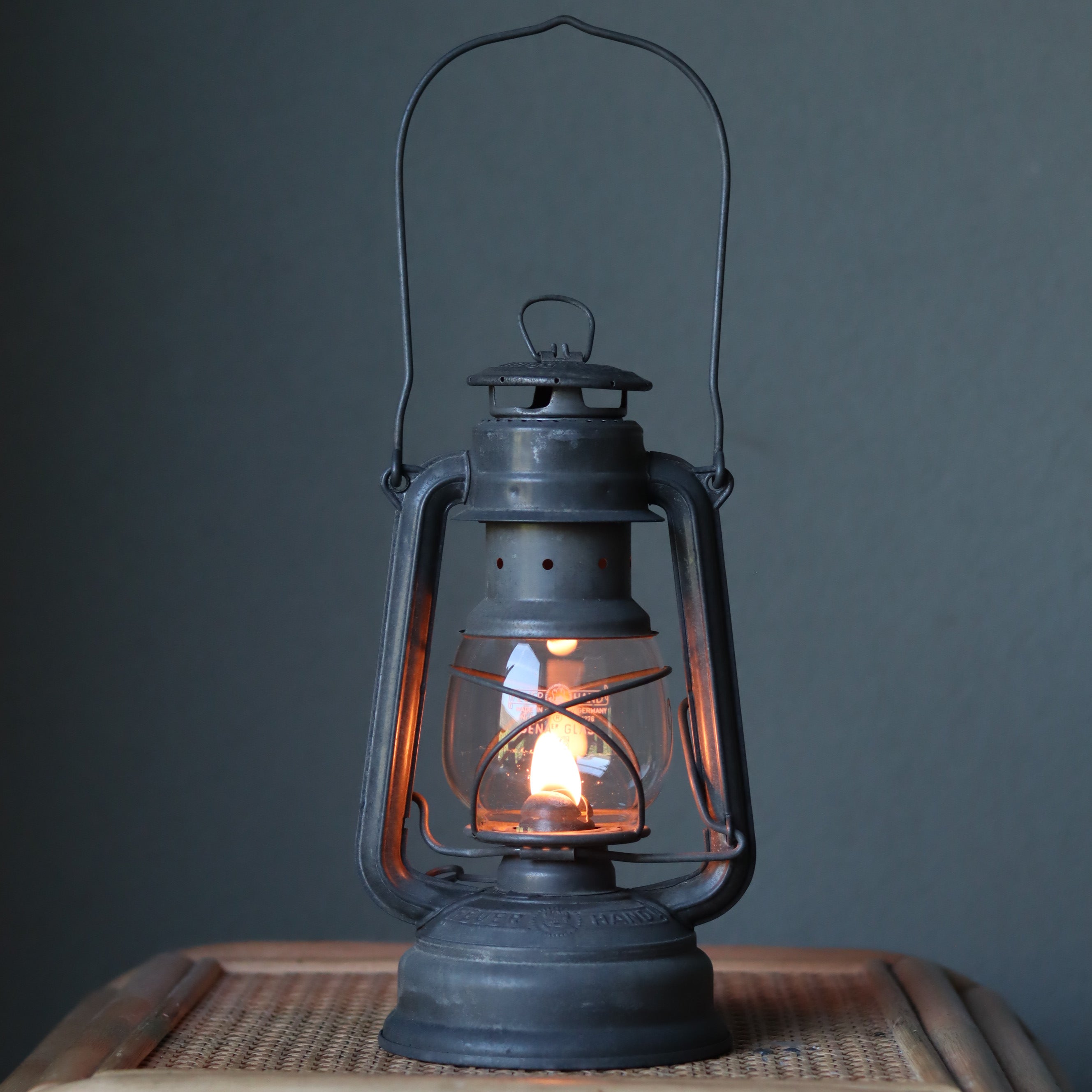 Restored Vintage Feuerhand Baby 275 Hurricane Lantern – Western Germany oil lamp glowing with warm flame on wooden surface
