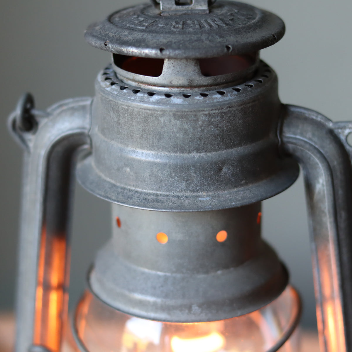 Restored Vintage Feuerhand Baby 275 Hurricane Lantern – Western Germany showing detailed metalwork and glowing oil lamp light