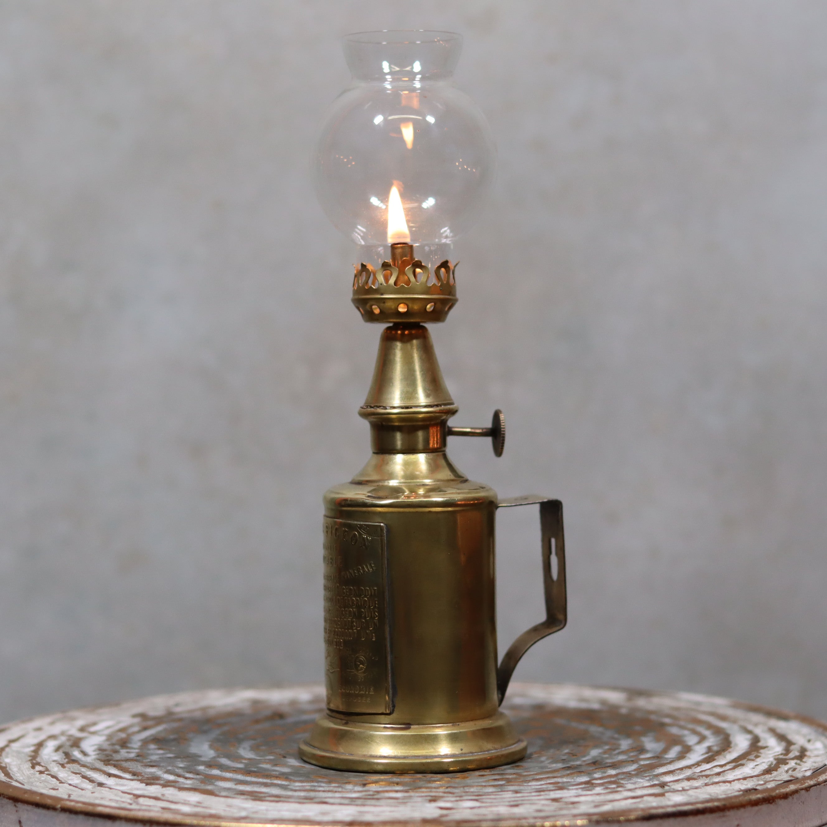 Rare Antique Oil Lamp – Early Pigeon Lamp (Circa 1900) with lit flame showcasing antique brass craftsmanship