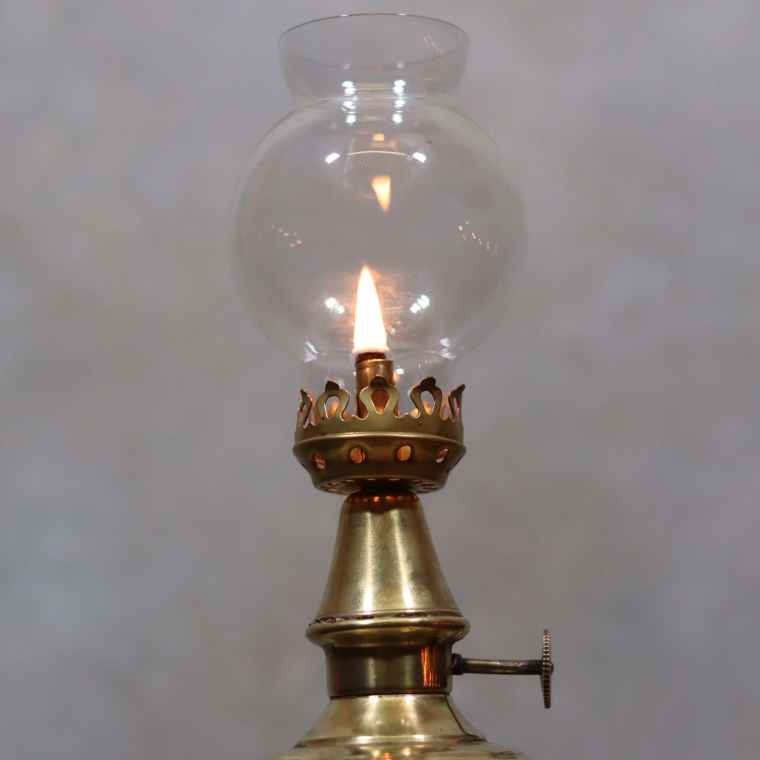 Rare Antique Oil Lamp – Early Pigeon Lamp (Circa 1900) burning with clear glass chimney and brass base detail