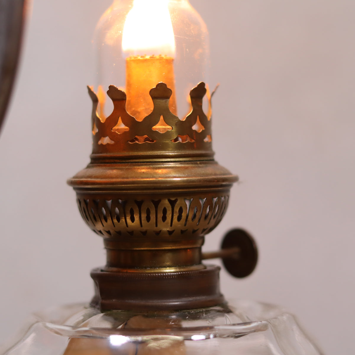 Close-up of lit Vintage Oil Lamp – Classic Wall or Kitchen Lamp with Silver Reflector showcasing detailed brass crown and glass chimney
