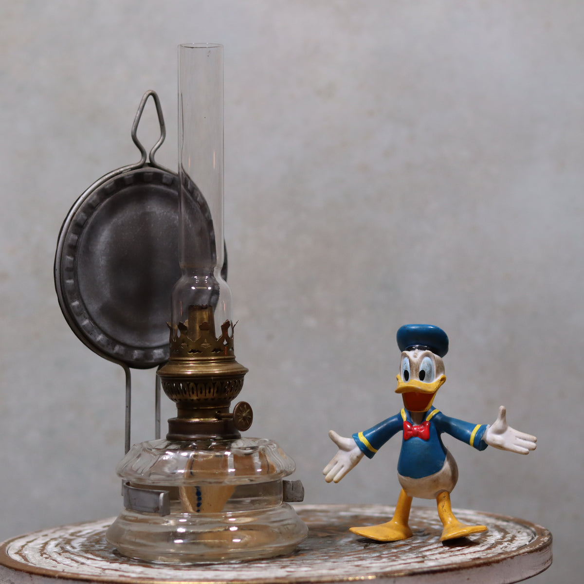 Vintage Oil Lamp – Classic Wall or Kitchen Lamp with Silver Reflector displayed on a rustic surface beside a toy figure.