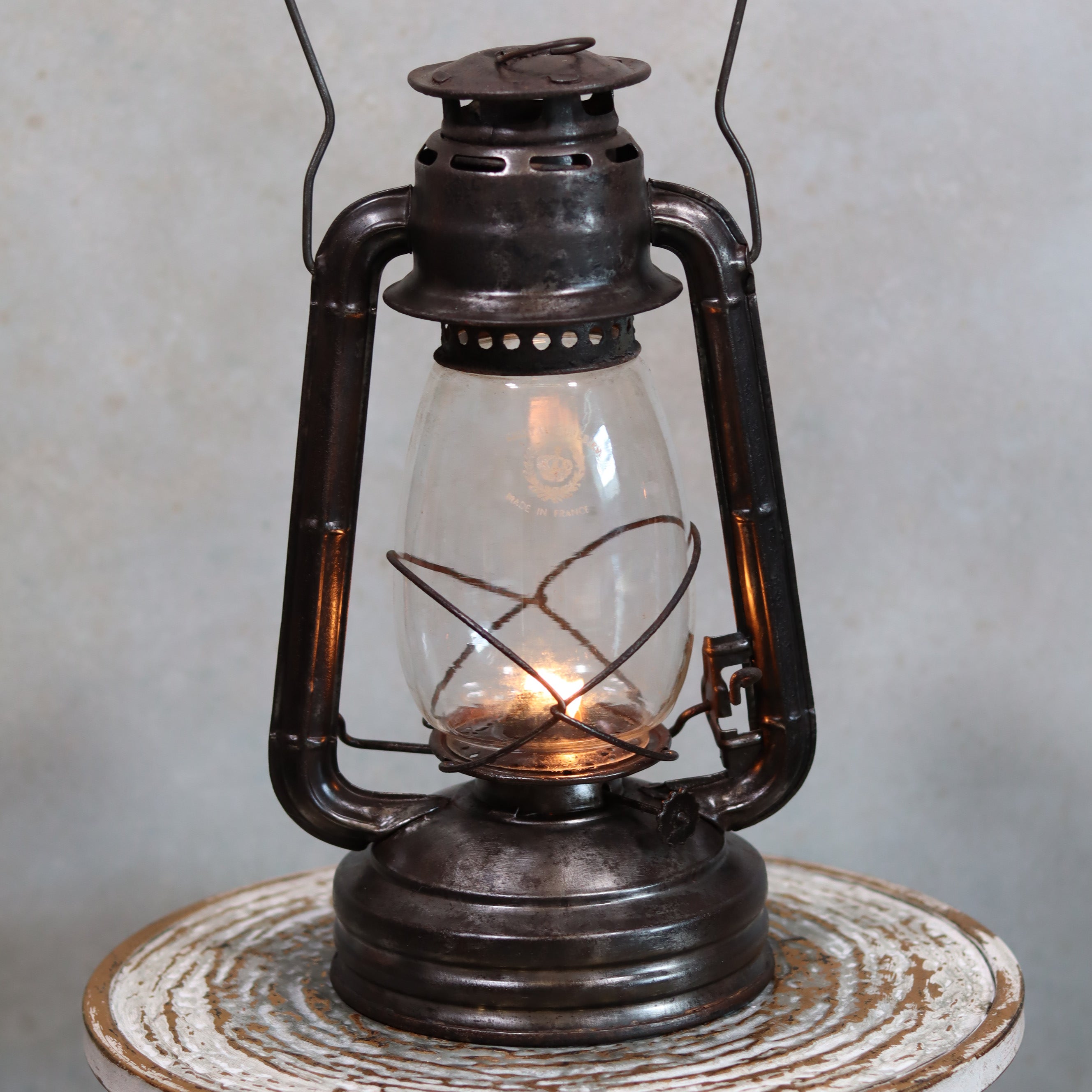 Vintage French ALG No. 6 Hurricane Lantern – Cristal Supérieur Glass (1930s) oil lamp lit on rustic table