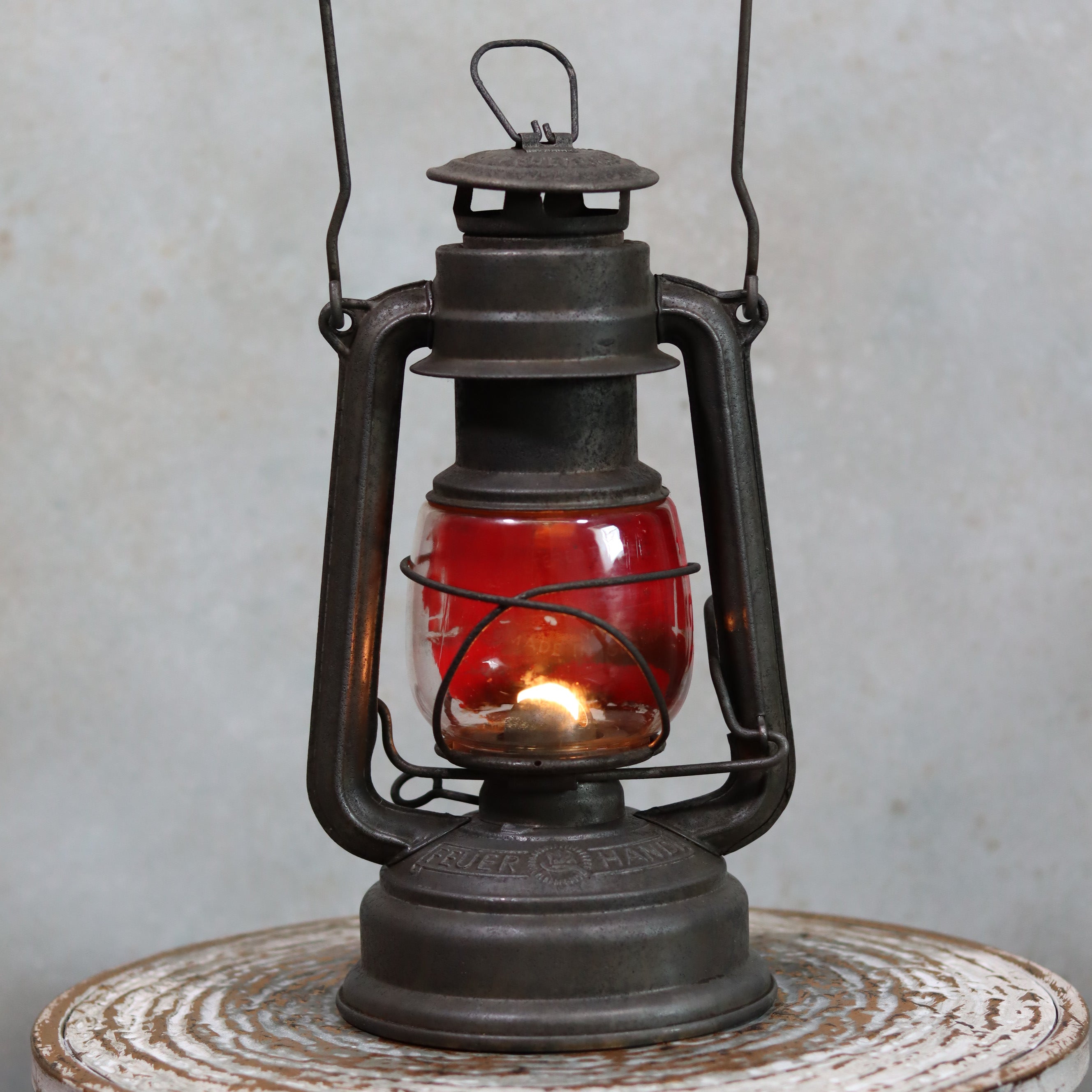Vintage Feuerhand Hurricane Lantern – Model 276 (1950s) with rare glass oil lamp showing classic metal frame and red glass.