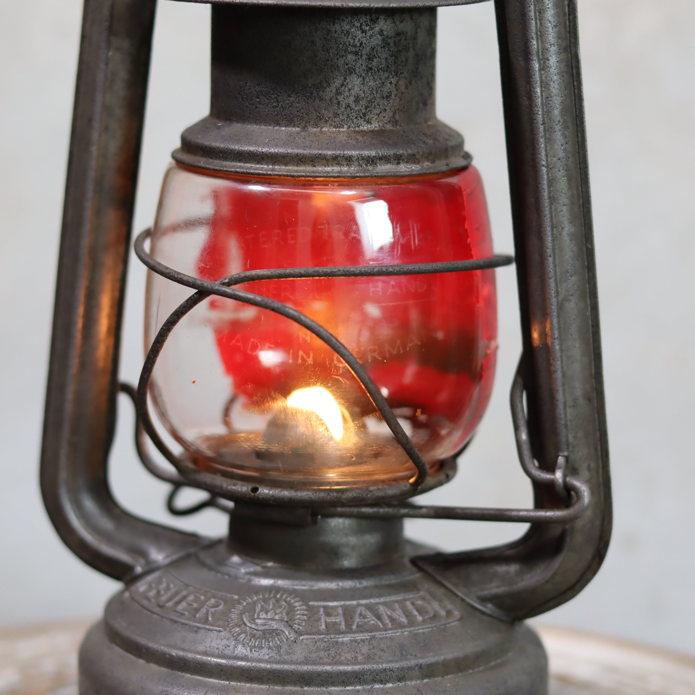 Vintage Feuerhand Hurricane Lantern – Model 276 (1950s) with rare glass showing lit flame inside metal oil lamp frame