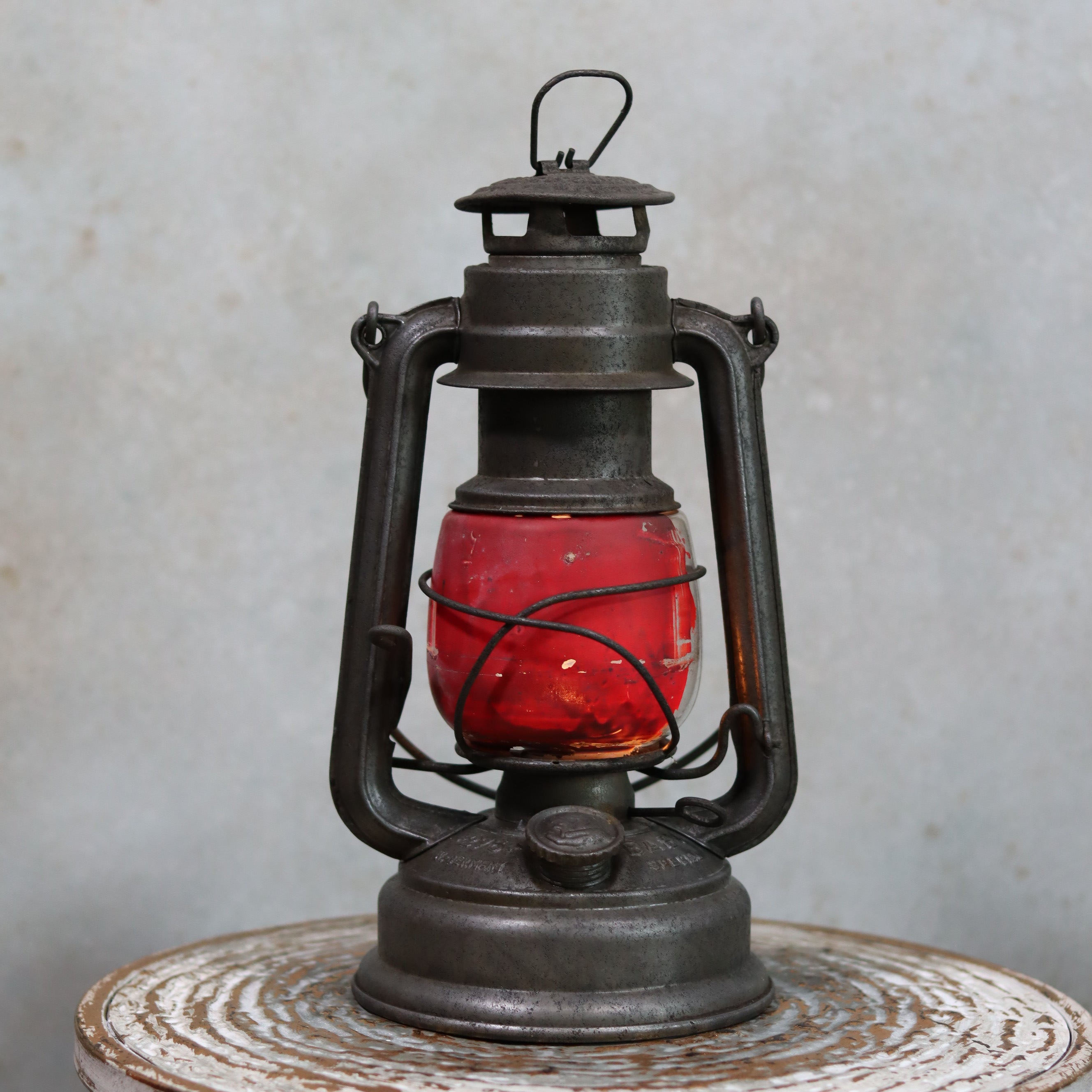 Vintage Feuerhand Hurricane Lantern – Model 276 (1950s) with rare glass oil lamp featuring classic black metal frame and red glass globe