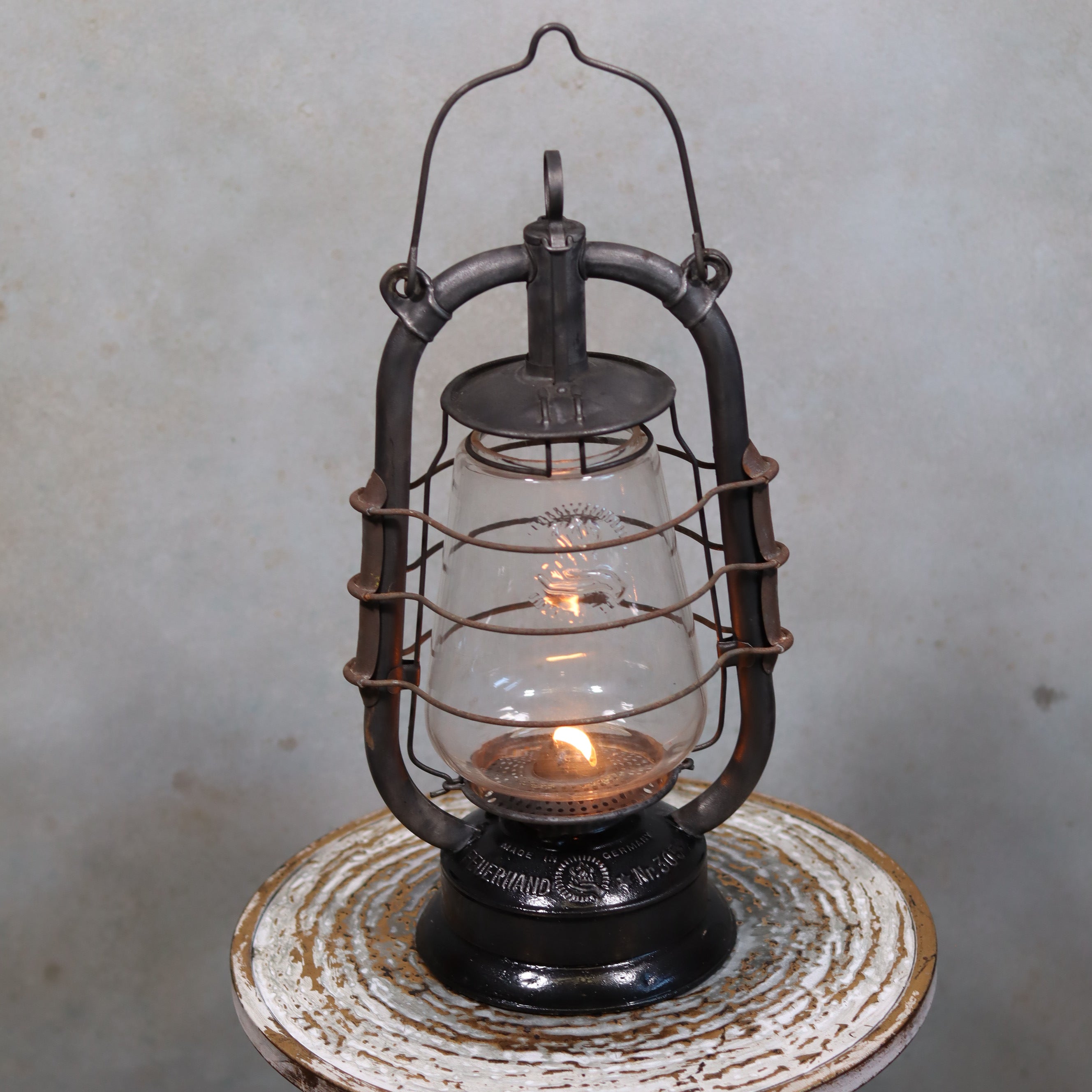 Rare Feuerhand 305 Hurricane Lantern – German Vintage Model with Black Tank (1930–1941) showing lit oil lamp design.