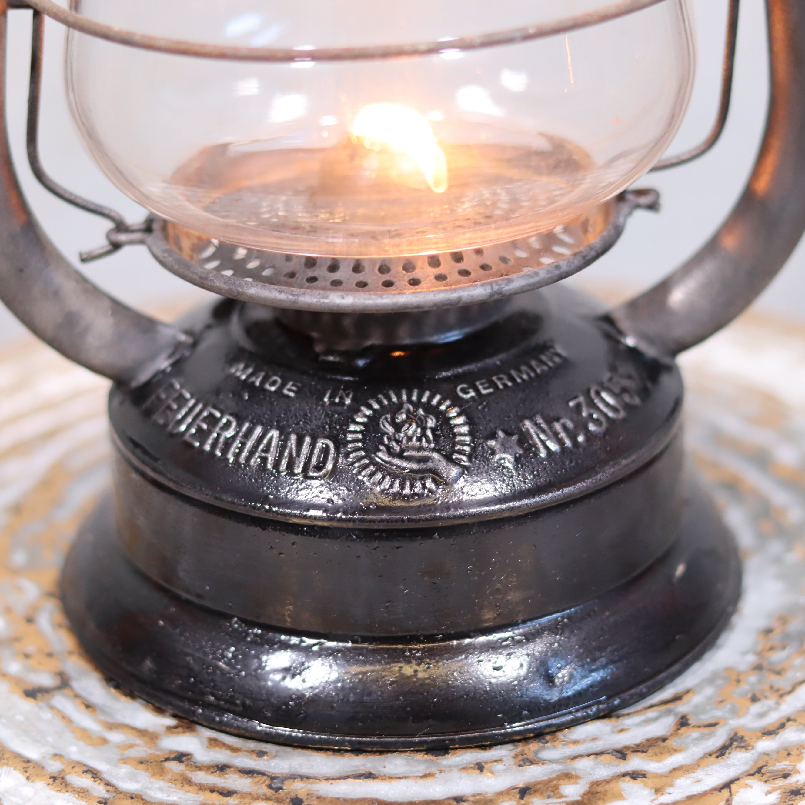 Rare Feuerhand 305 Hurricane Lantern – German Vintage Model with Black Tank (1930–1941) showing lit oil lamp detail.