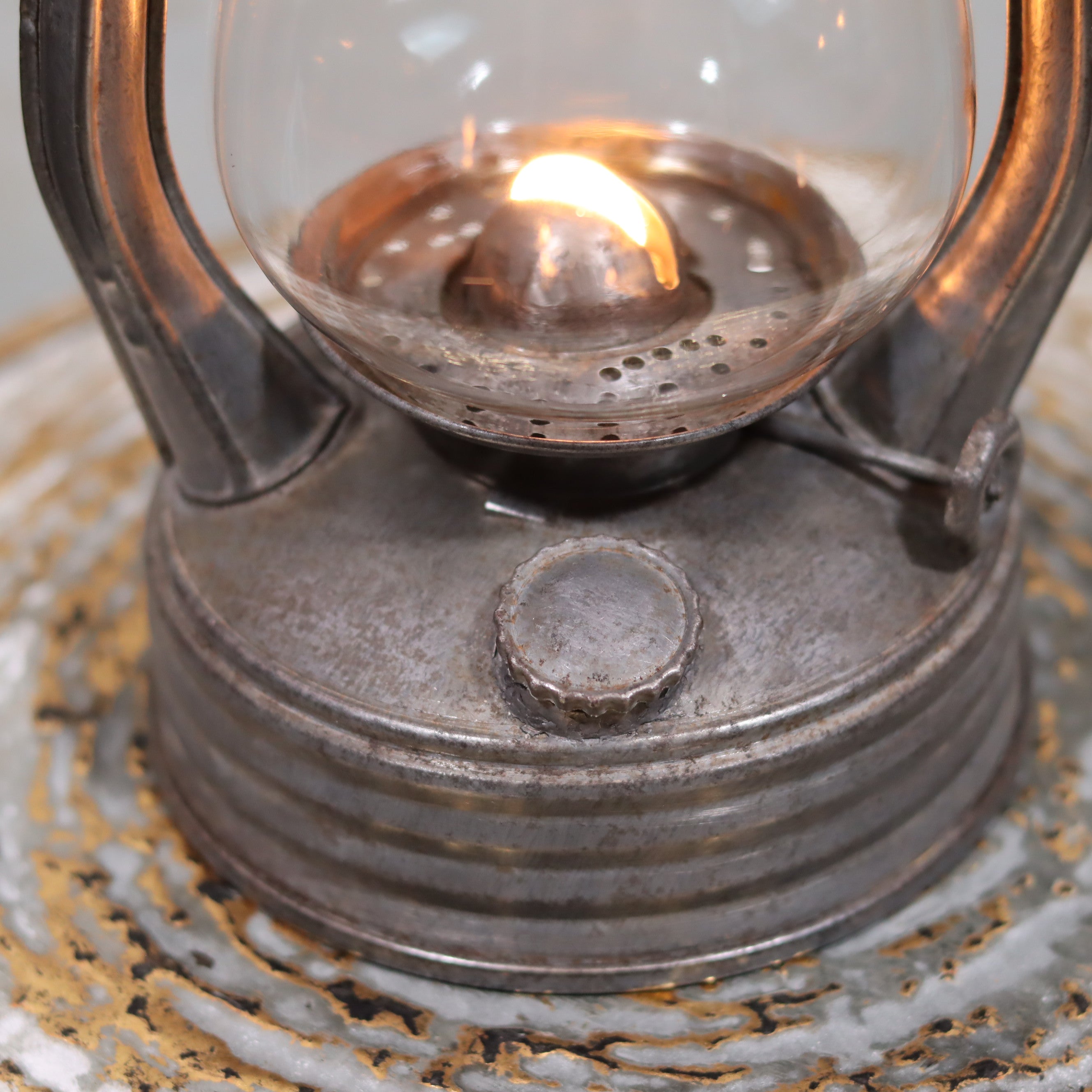 Vintage French Royalux Hurricane Lantern – Glass Lift Mechanism (27 cm) with lit oil lamp and rustic metal base close-up view