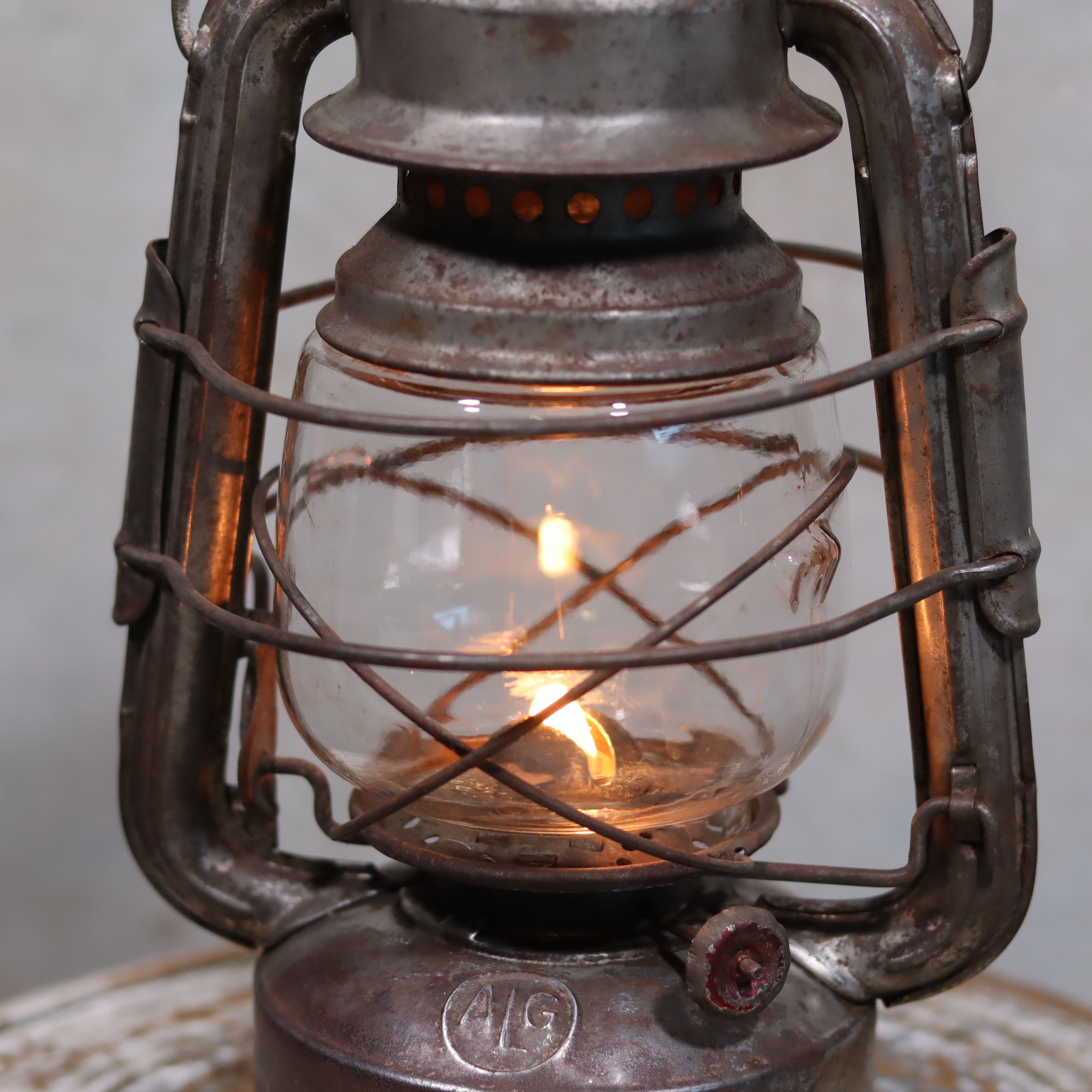 Vintage French ALG Guillouard Hurricane Lantern – Luciole Model (1960s–1980s) glowing oil lamp with metal frame and glass chimney.