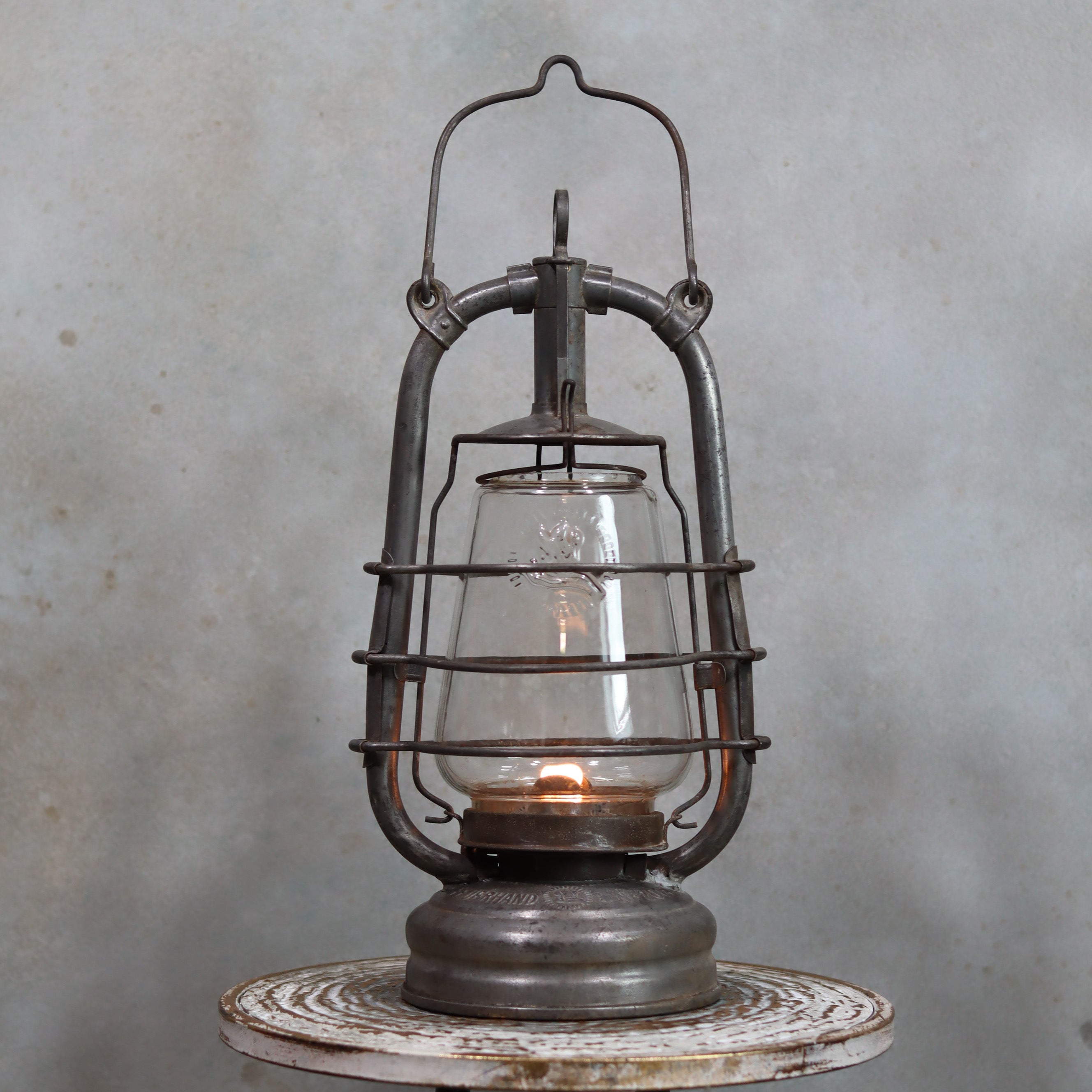 Vintage Feuerhand 201 Storm Lantern – Rare Glass, 1920s–1930s, Well-Worn Patina with lit oil lamp inside protective metal frame