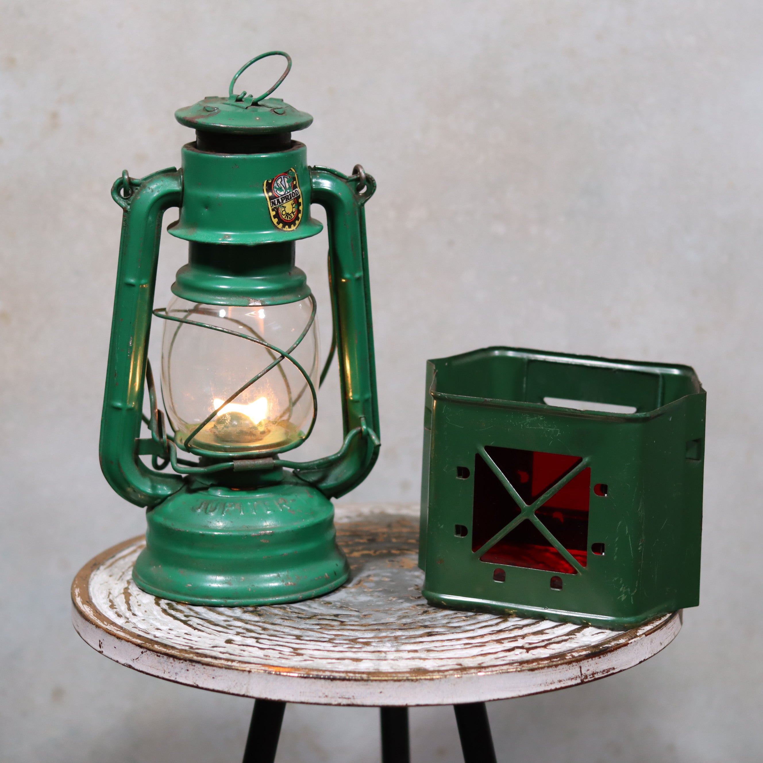 Rare Vintage Jupiter-1 Green Hurricane Lantern – With Unique Glass Holder & Original Sticker on rustic table with soft light glow