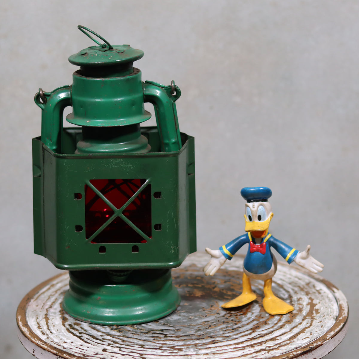 Rare Vintage Jupiter-1 Green Hurricane Lantern – With Unique Glass Holder & Original Sticker displayed on rustic surface alongside figure