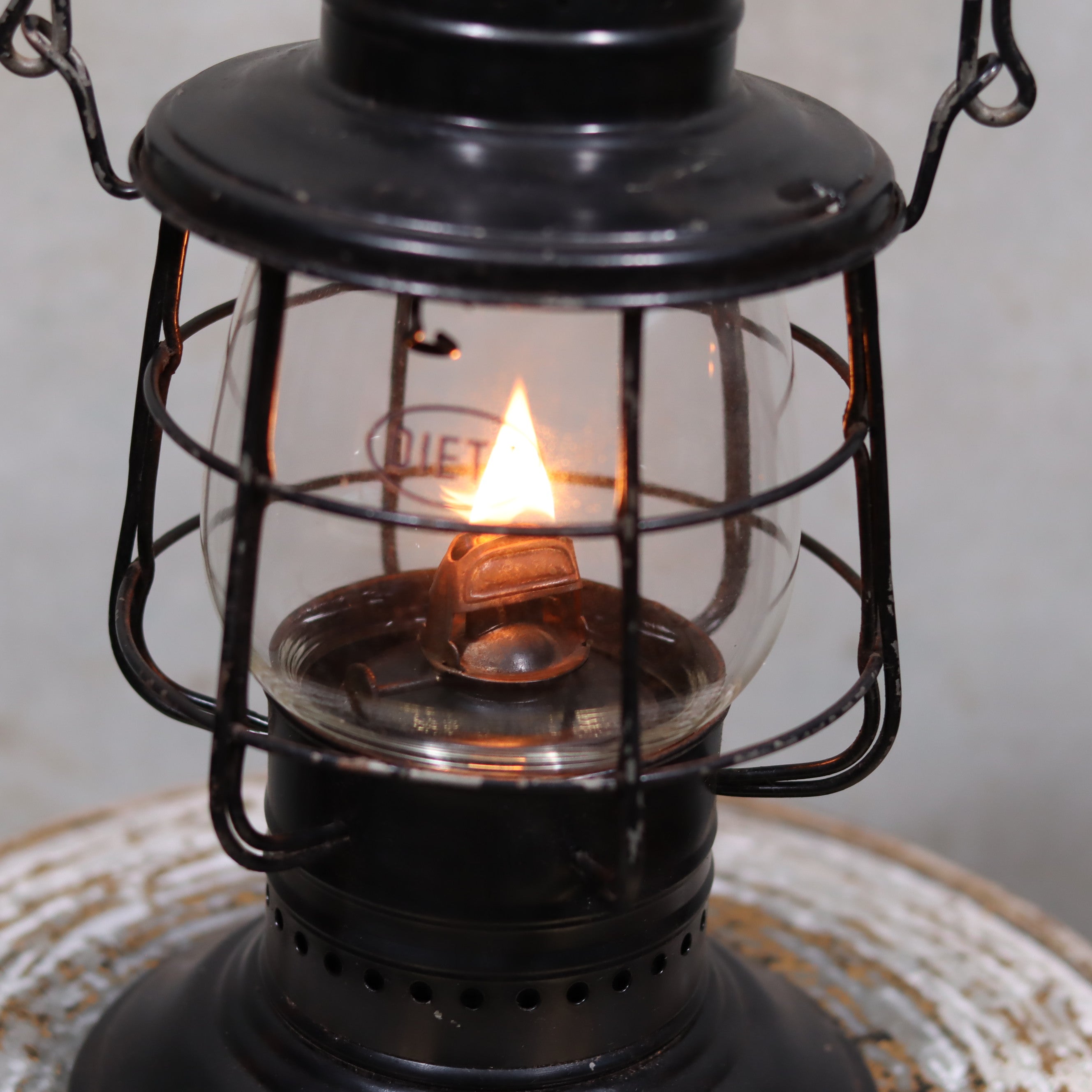 Vintage Keystone Ware Hurricane Lantern – Black Finish with Dietz Glass featuring a burning oil lamp flame close-up detail