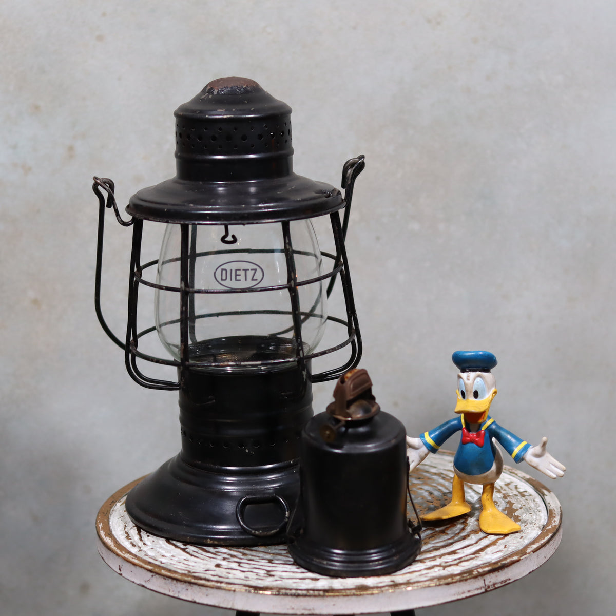 Vintage Keystone Ware Hurricane Lantern – Black Finish with Dietz Glass oil lamp displayed on rustic table next to a small figurine