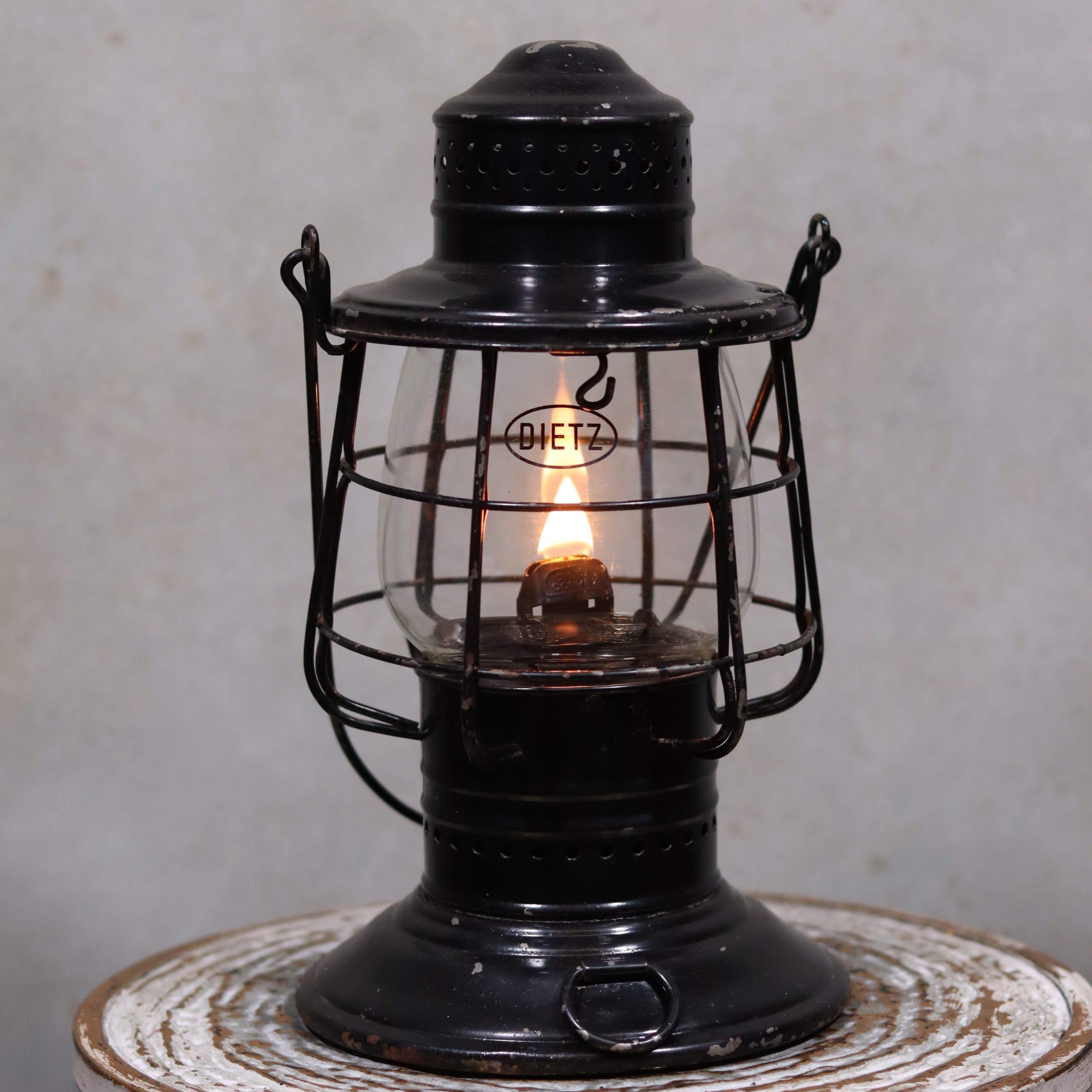 Vintage Keystone Ware Hurricane Lantern – Black Finish with Dietz Glass oil lamp lit indoors on a rustic surface