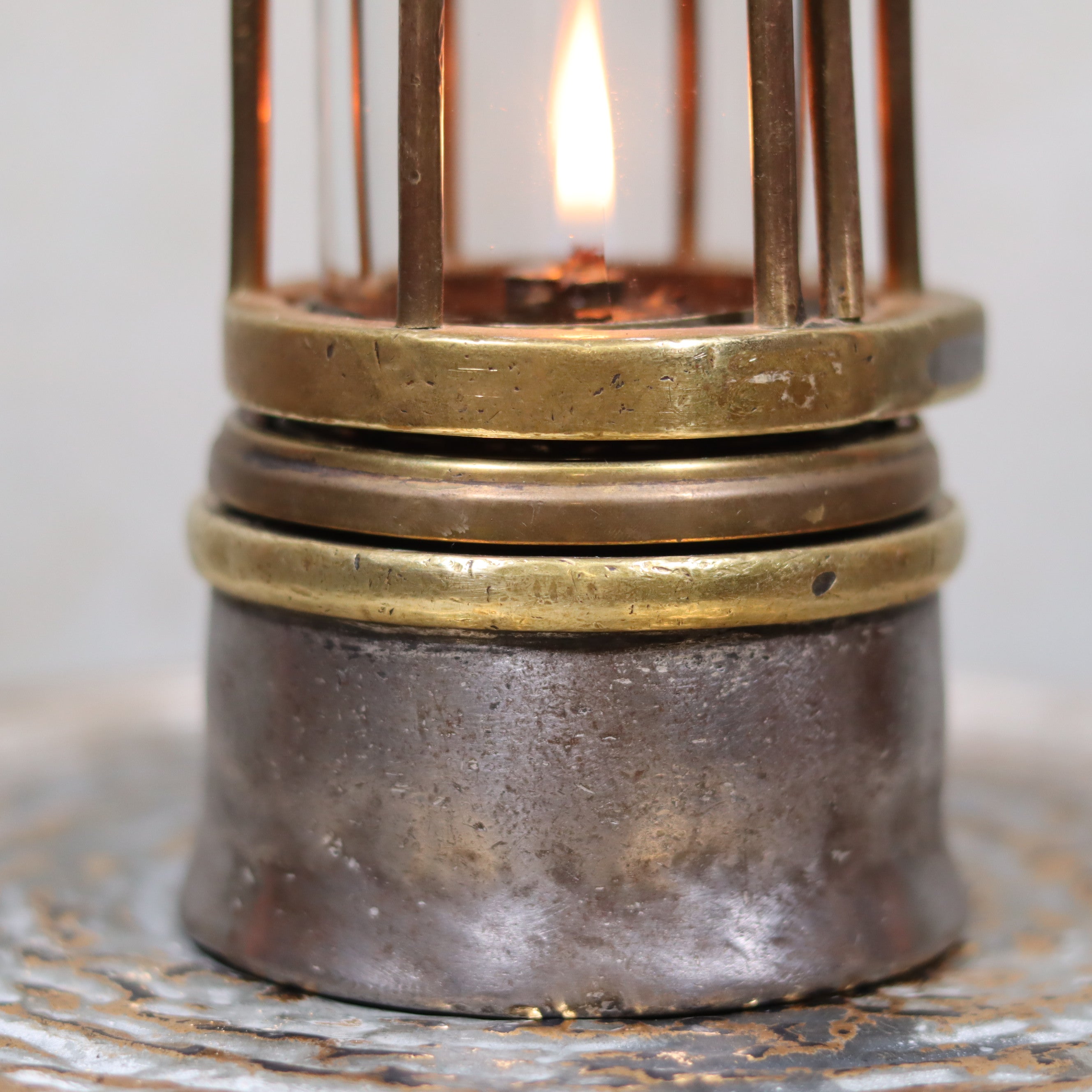 Close-up of lit oil lamp base in Antique Mining Lamp – Hubert Joris – Circa 1900–1910 – Belgian Master Miner’s Lamp
