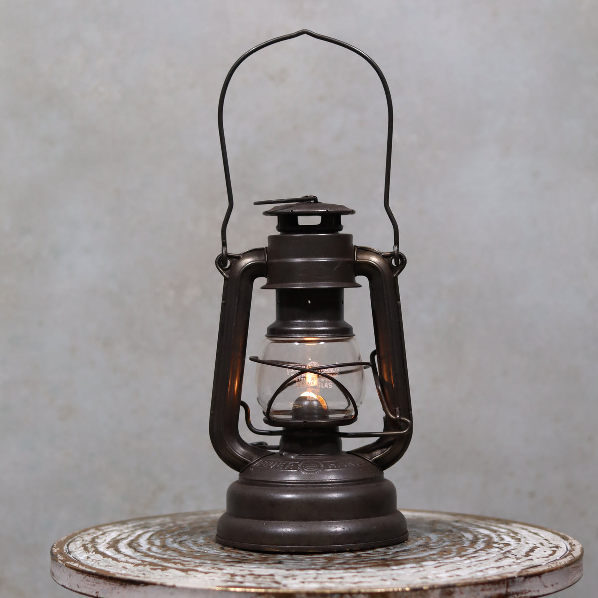 Vintage Feuerhand 176 Storm Lantern – Post-WWII Model, 1950s, Excellent Condition oil lamp lit on rustic wooden table