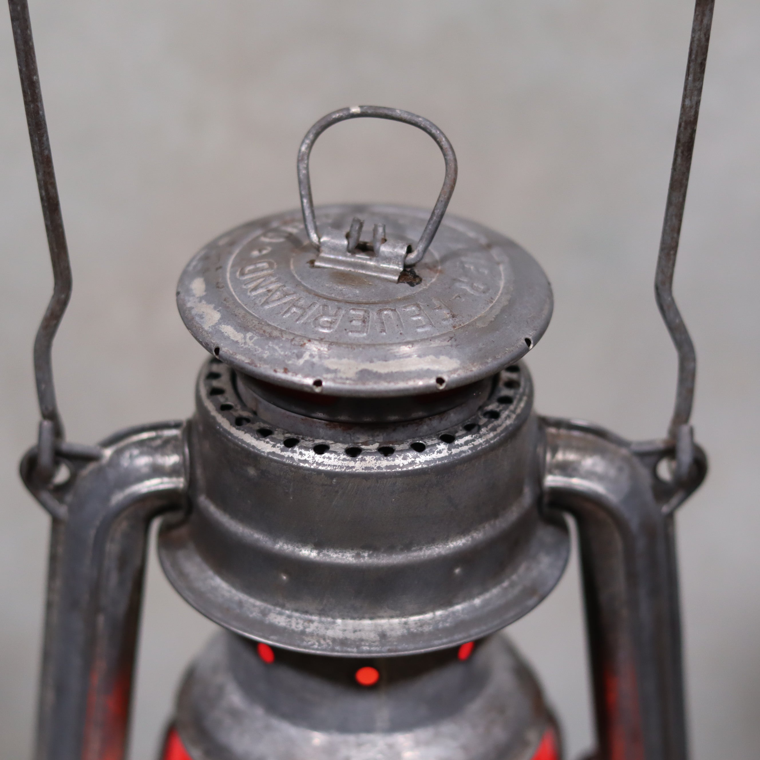 Close-up of the metal top and handle of the Vintage Feuerhand Baby 275 Hurricane Lantern – Western Germany – Red Glass