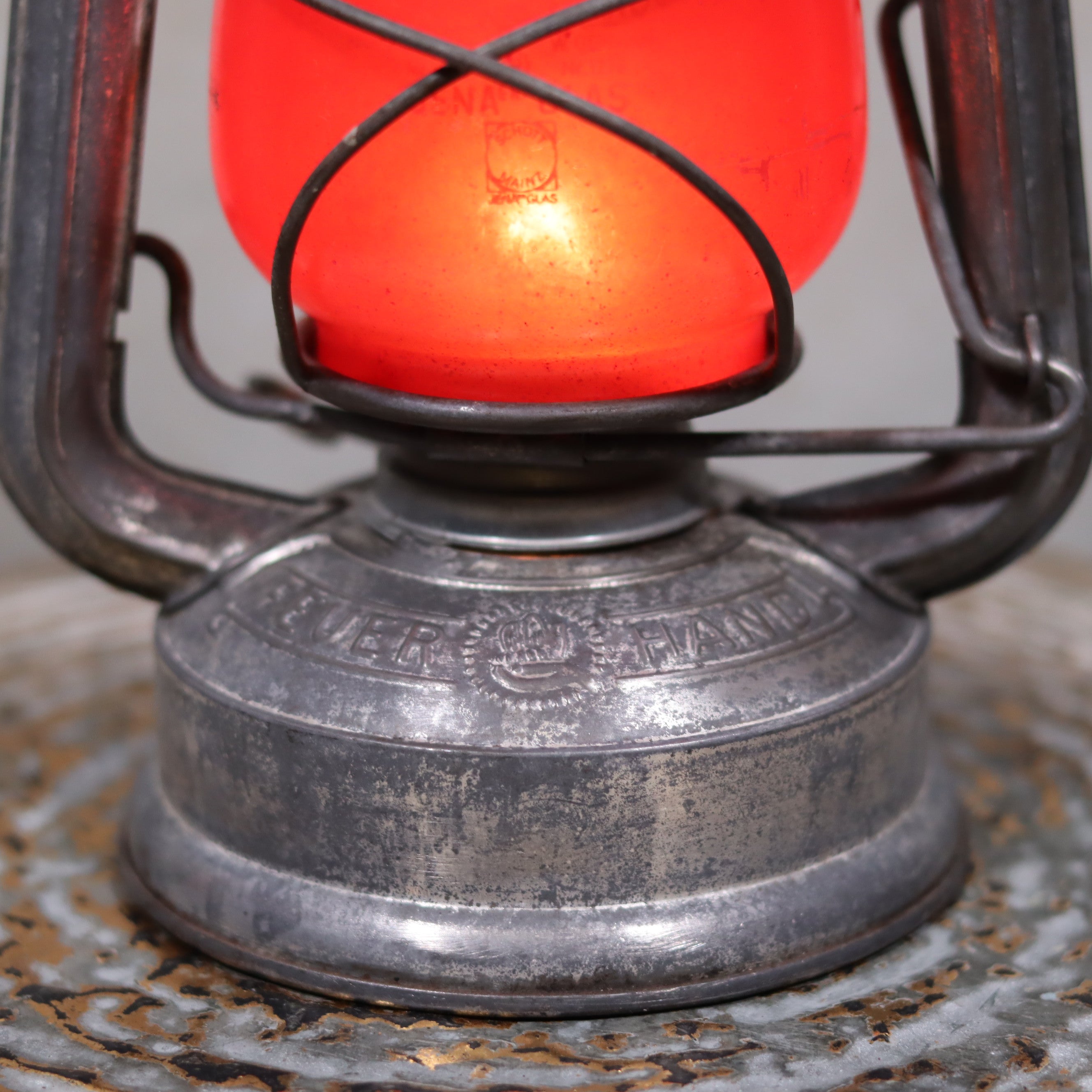 Vintage Feuerhand Baby 275 Hurricane Lantern – Western Germany – Red Glass oil lamp showing detailed metal base and glowing red glass globe