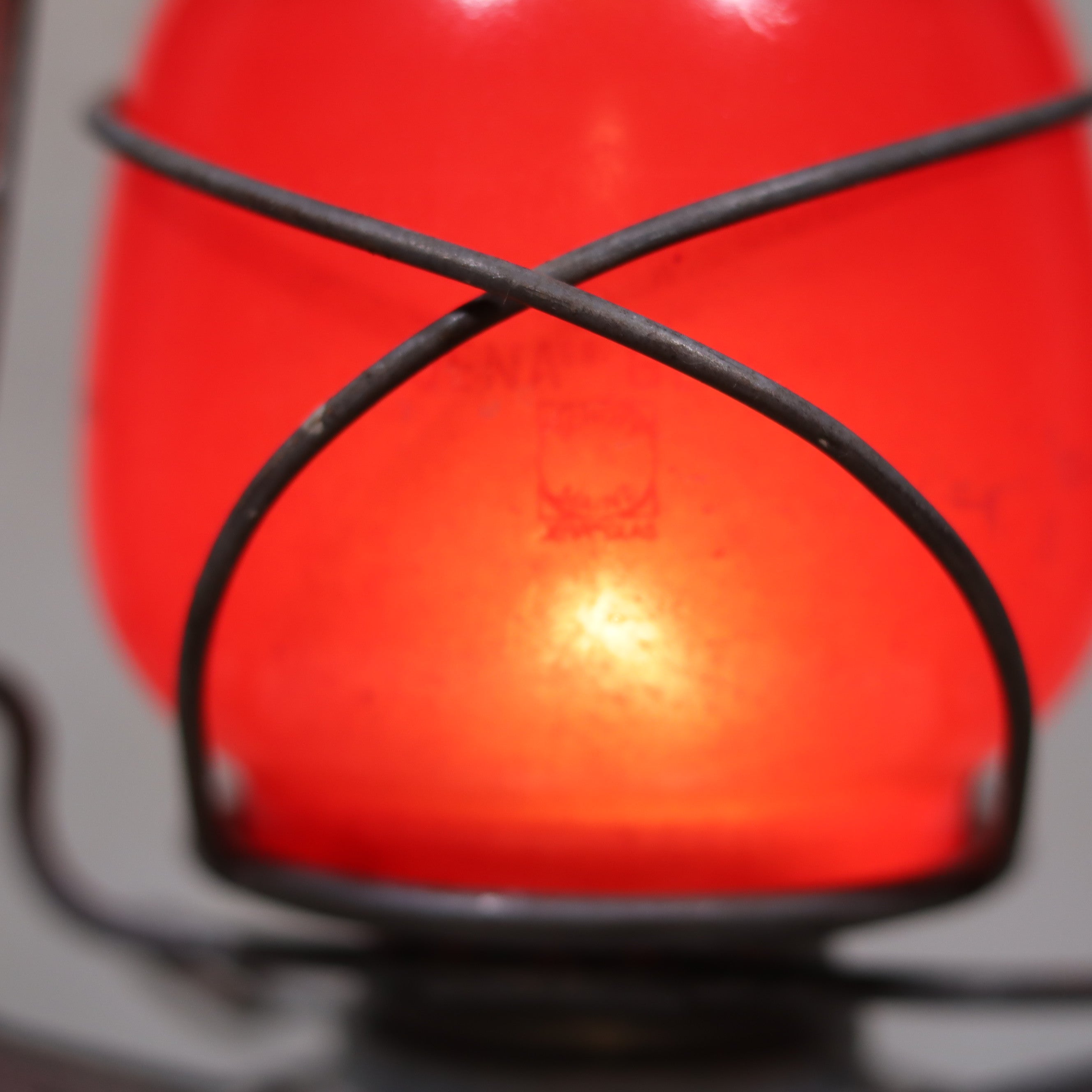 Close-up of the red glass and metal frame of the Vintage Feuerhand Baby 275 Hurricane Lantern – Western Germany – Red Glass