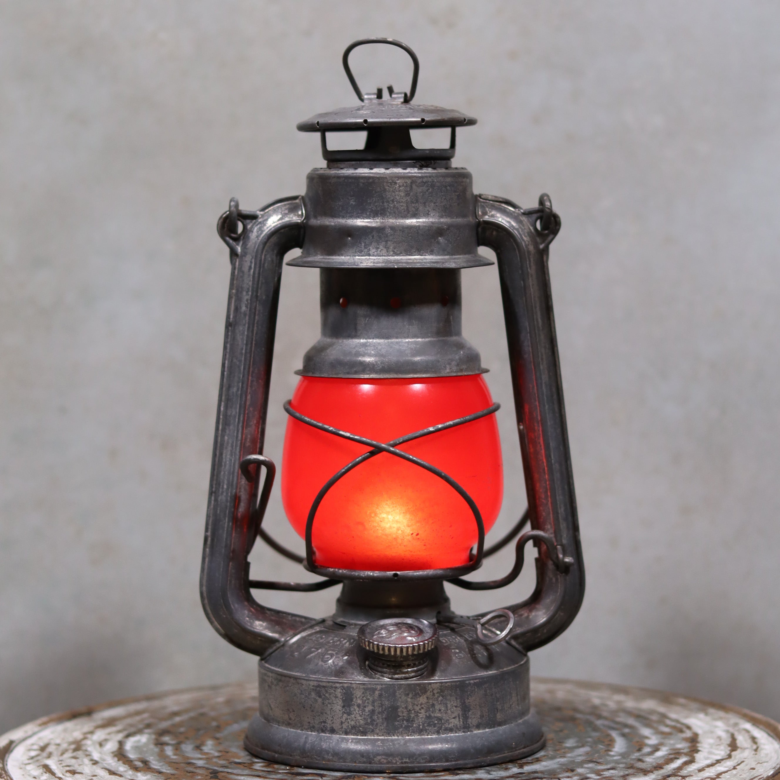 Vintage Feuerhand Baby 275 Hurricane Lantern – Western Germany – Red Glass oil lamp with weathered metal frame and glowing red glass shade