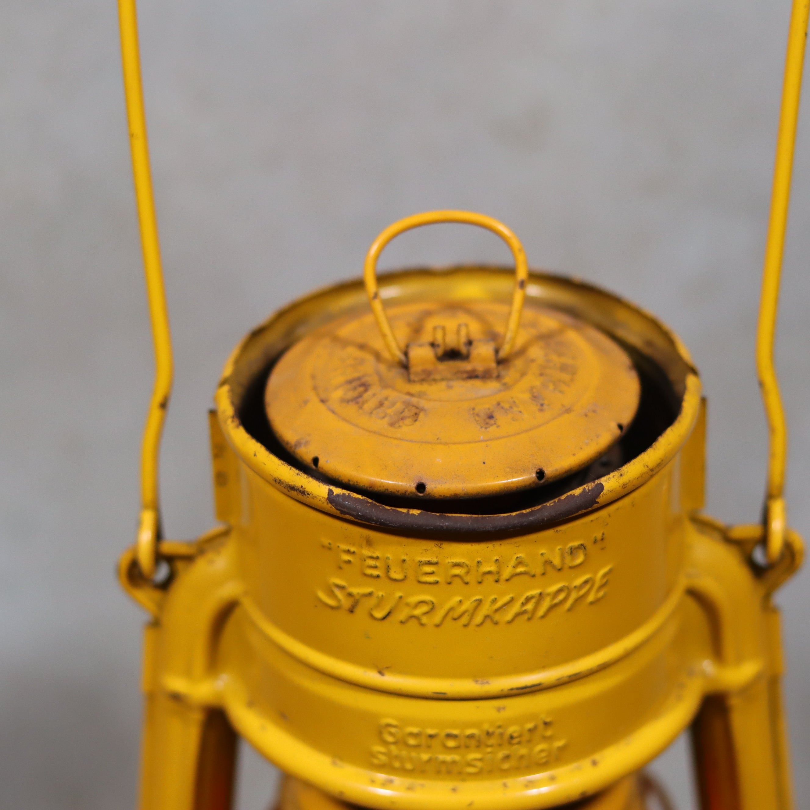 Vintage Feuerhand Hurricane Lantern – Baby Special 276 STK/70 showing close-up of yellow oil lamp top with brand embossing