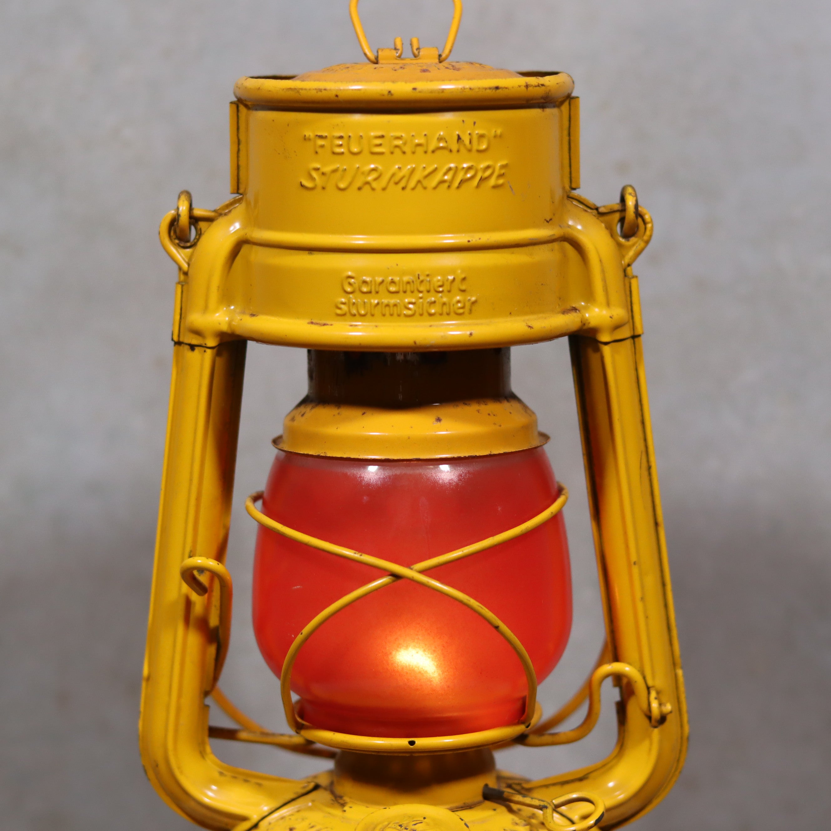 Vintage Feuerhand Hurricane Lantern – Baby Special 276 STK/70 showcasing classic yellow oil lamp design with red glass globe.