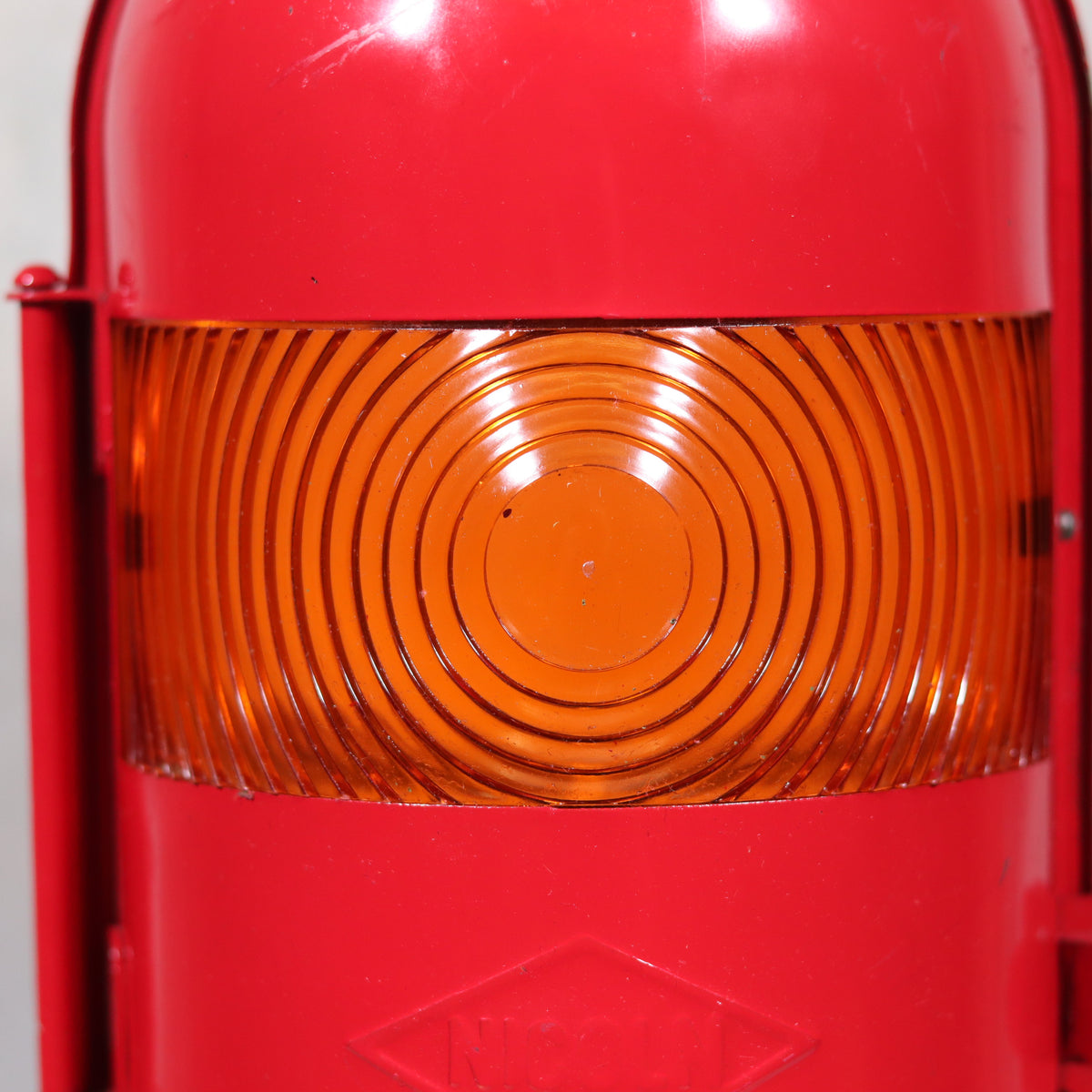 Close-up of the orange lens on the NOS Vintage Nicoln Flashing Oil Lamp – Road Worker Lantern with Original Manual