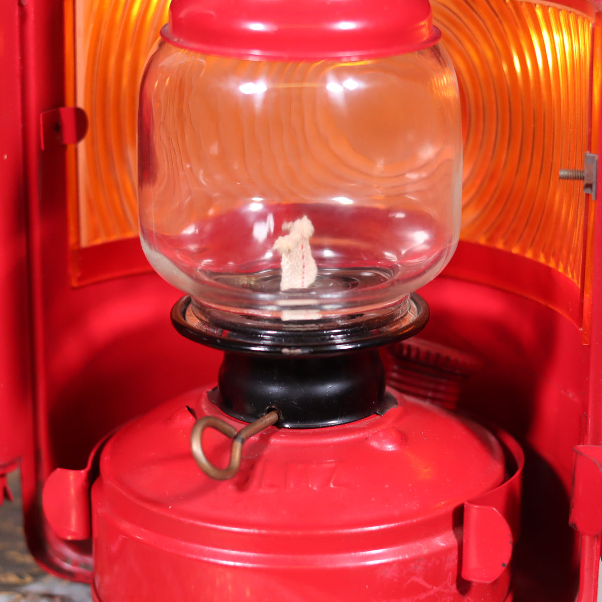 Close-up of the red NOS Vintage Nicoln Flashing Oil Lamp – Road Worker Lantern with Original Manual showing its glass and wick detail.