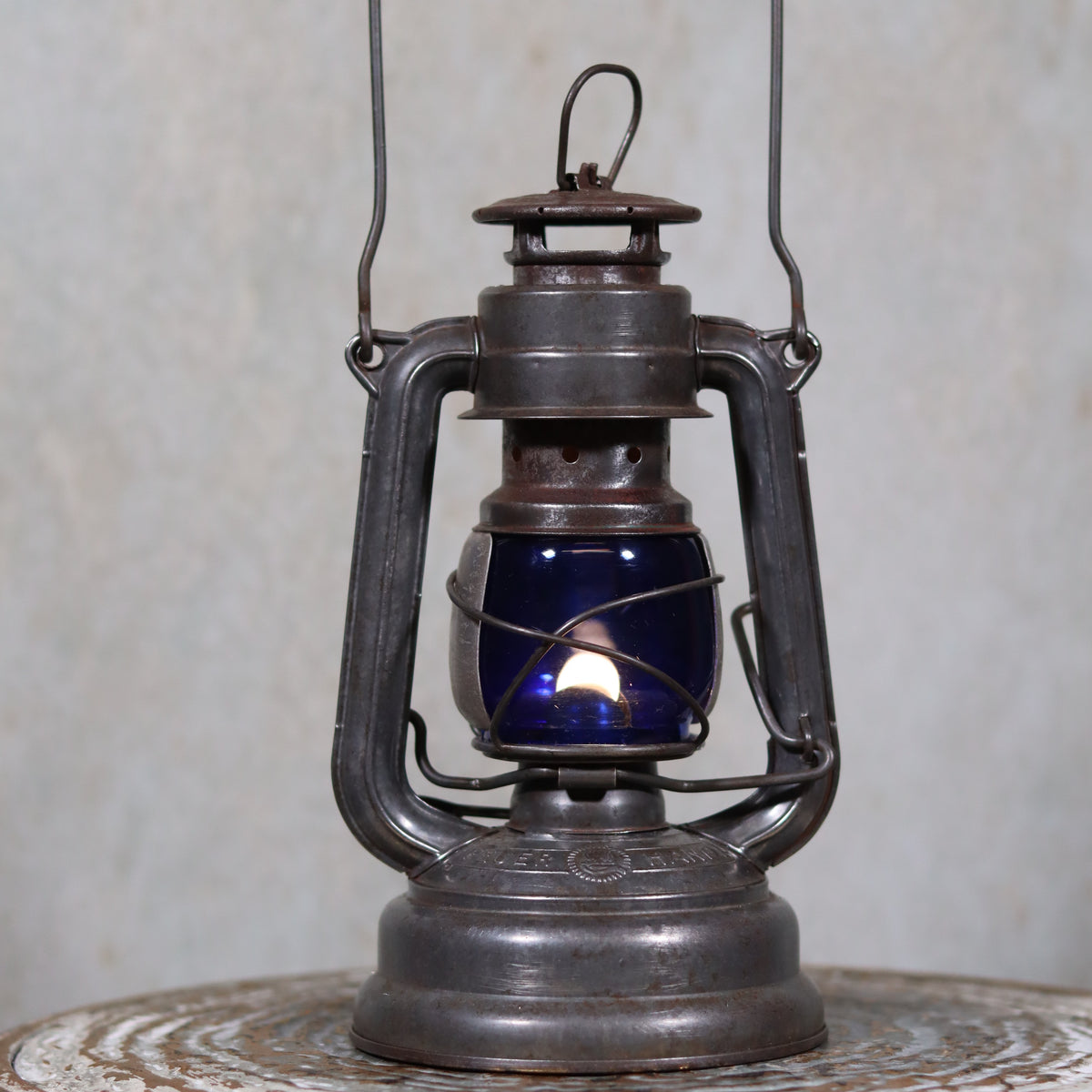 Vintage Feuerhand 176 Hurricane Lantern – 1960s – Superb Condition with Blue Glass & Reflector oil lamp shown lit on rustic surface