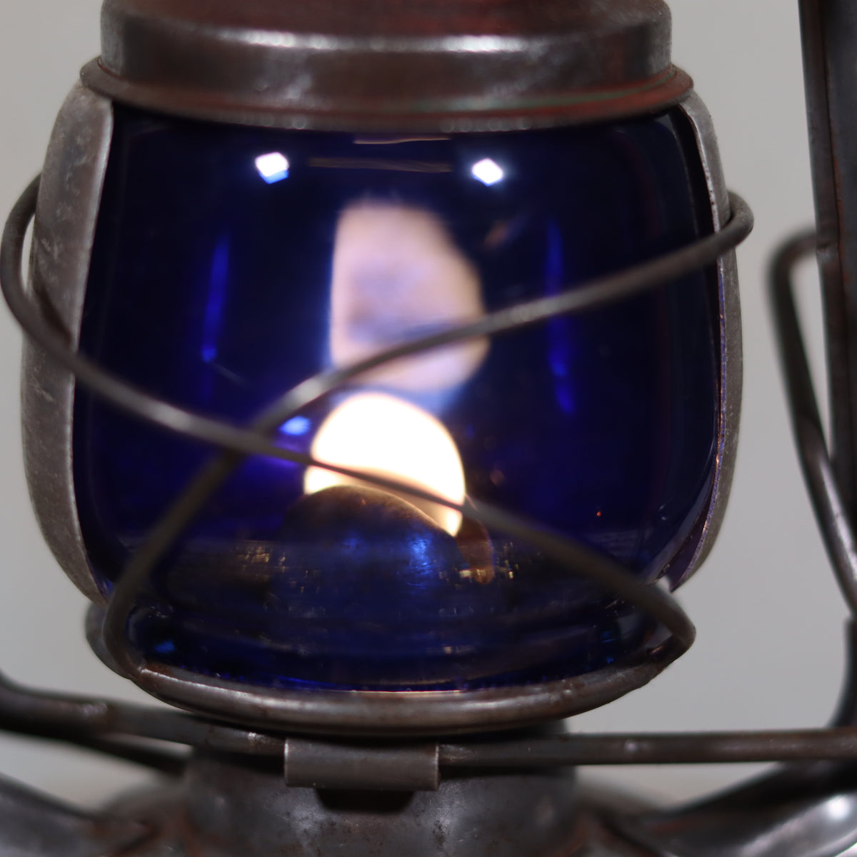 Vintage Feuerhand 176 Hurricane Lantern – 1960s – Superb Condition with Blue Glass & Reflector, lit oil lamp close-up.