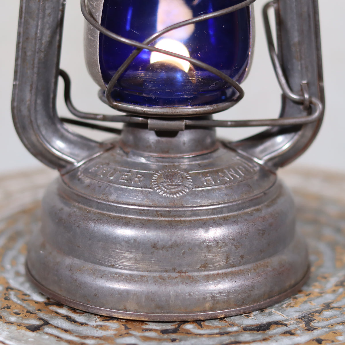 Vintage Feuerhand 176 Hurricane Lantern – 1960s – Superb Condition with Blue Glass & Reflector close-up on metal base and flame