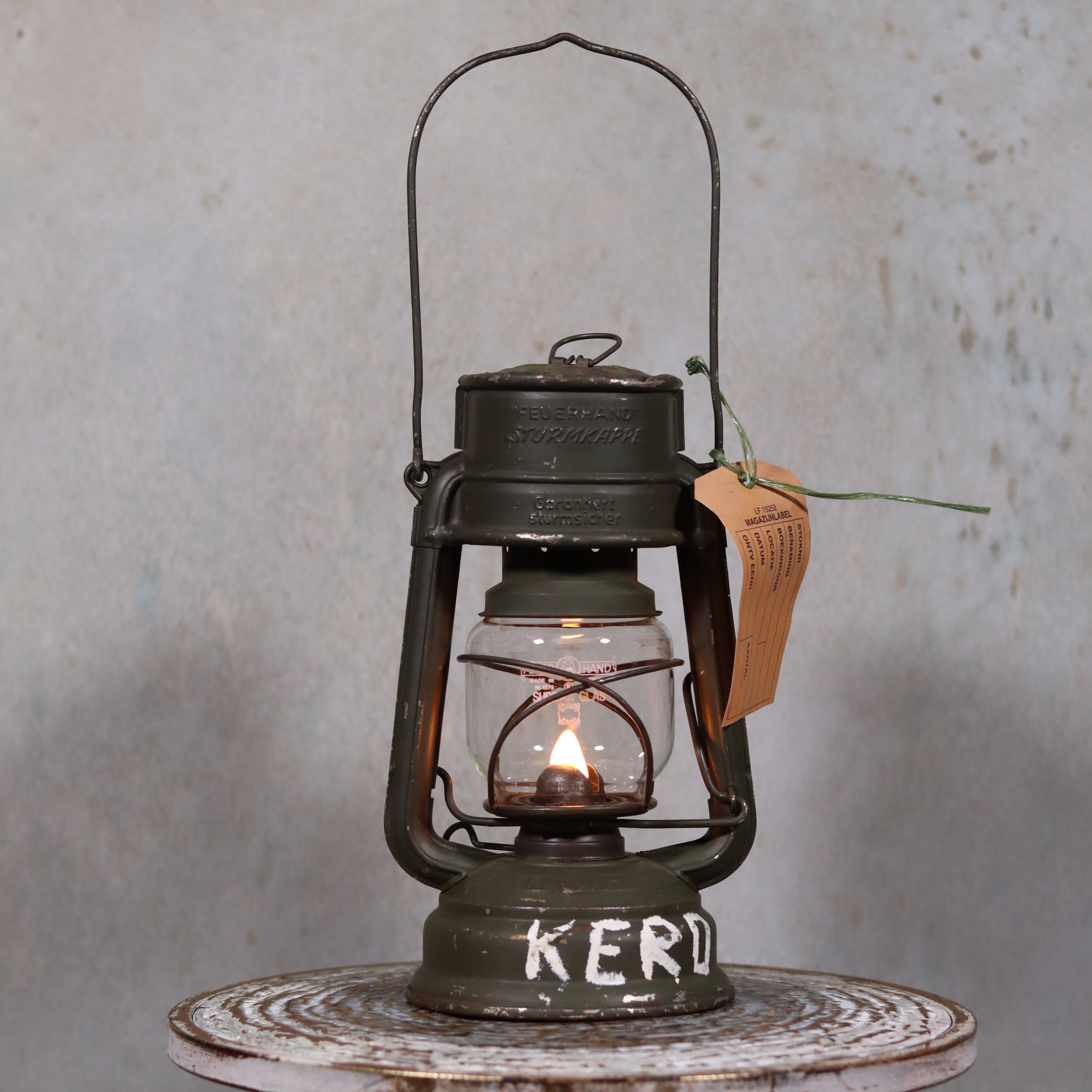 Vintage Feuerhand Hurricane Lantern – Baby Special 276 (1980s, KL-88 Military Marking) oil lamp lit on round surface