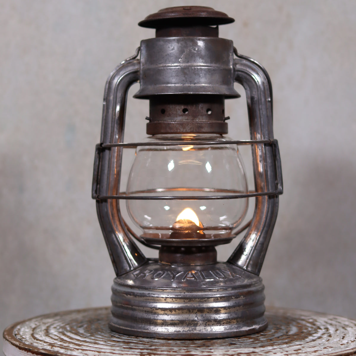Vintage French Royalux Hurricane Lantern – Rare Glass Lift & Cage (27 cm) showing lit oil lamp with metal frame and glass chimney